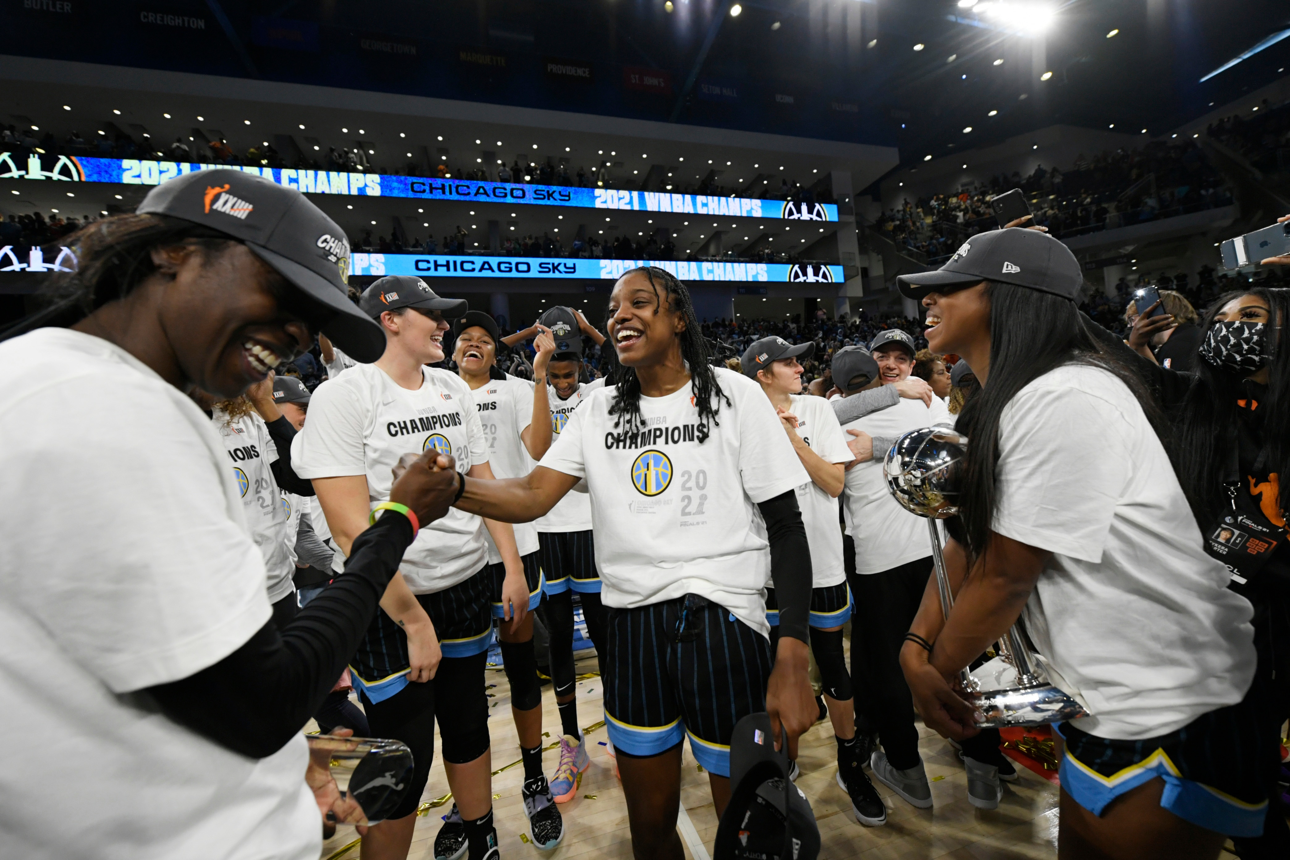 Chicago Sky's Diamond DeShields center, and Kahleah Copper left,akong with teammates celebrate after defeating the Phoenix Mercury in Game 4 of the WNBA Finals to become champions Sunday, Oct. 17, 2021, in Chicago. (AP Photo/Paul Beaty)
