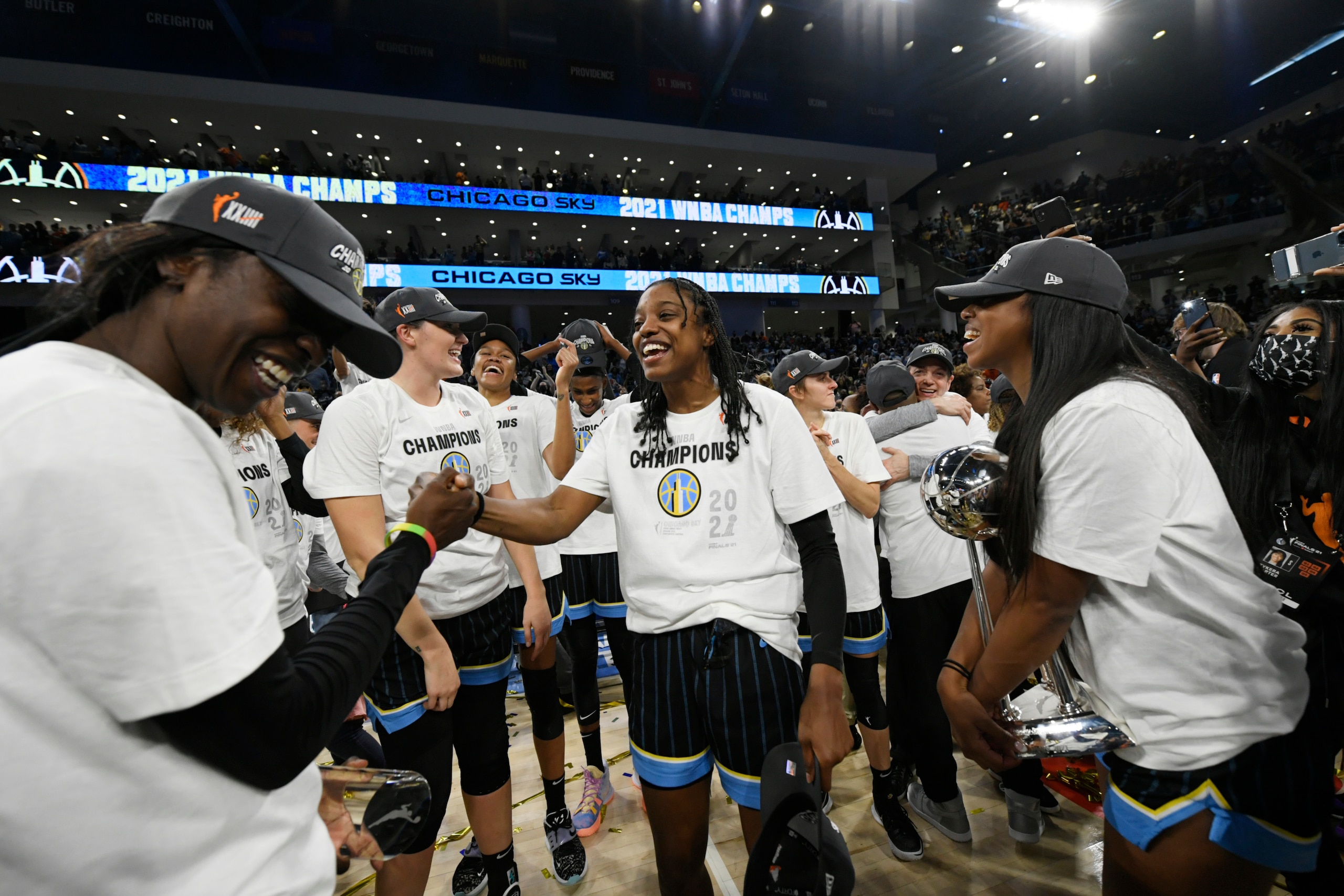 Chicago Sky's Diamond DeShields center, and Kahleah Copper left,akong with teammates celebrate after defeating the Phoenix Mercury in Game 4 of the WNBA Finals to become champions Sunday, Oct. 17, 2021, in Chicago. (AP Photo/Paul Beaty)