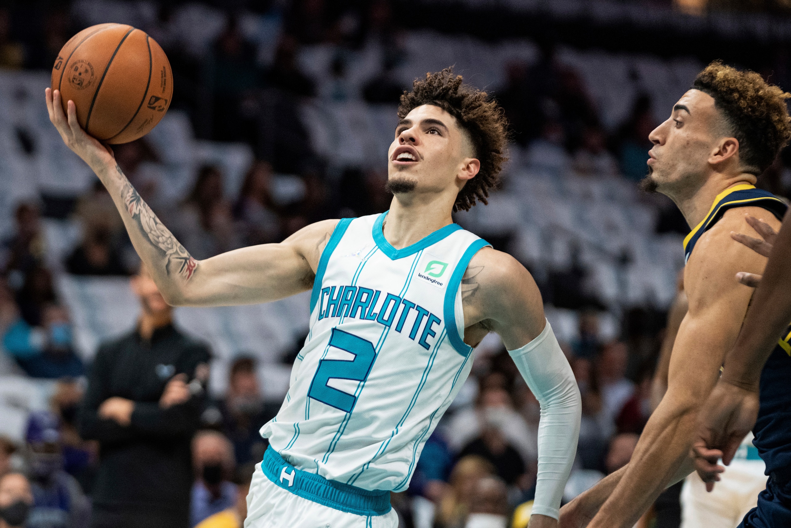 Charlotte Hornets guard LaMelo Ball drives to the basket while guarded by Indiana Pacers guard Chris Duarte during the first half of an NBA basketball game in Charlotte, N.C., Wednesday, Oct. 20, 2021. (AP Photo/Jacob Kupferman)