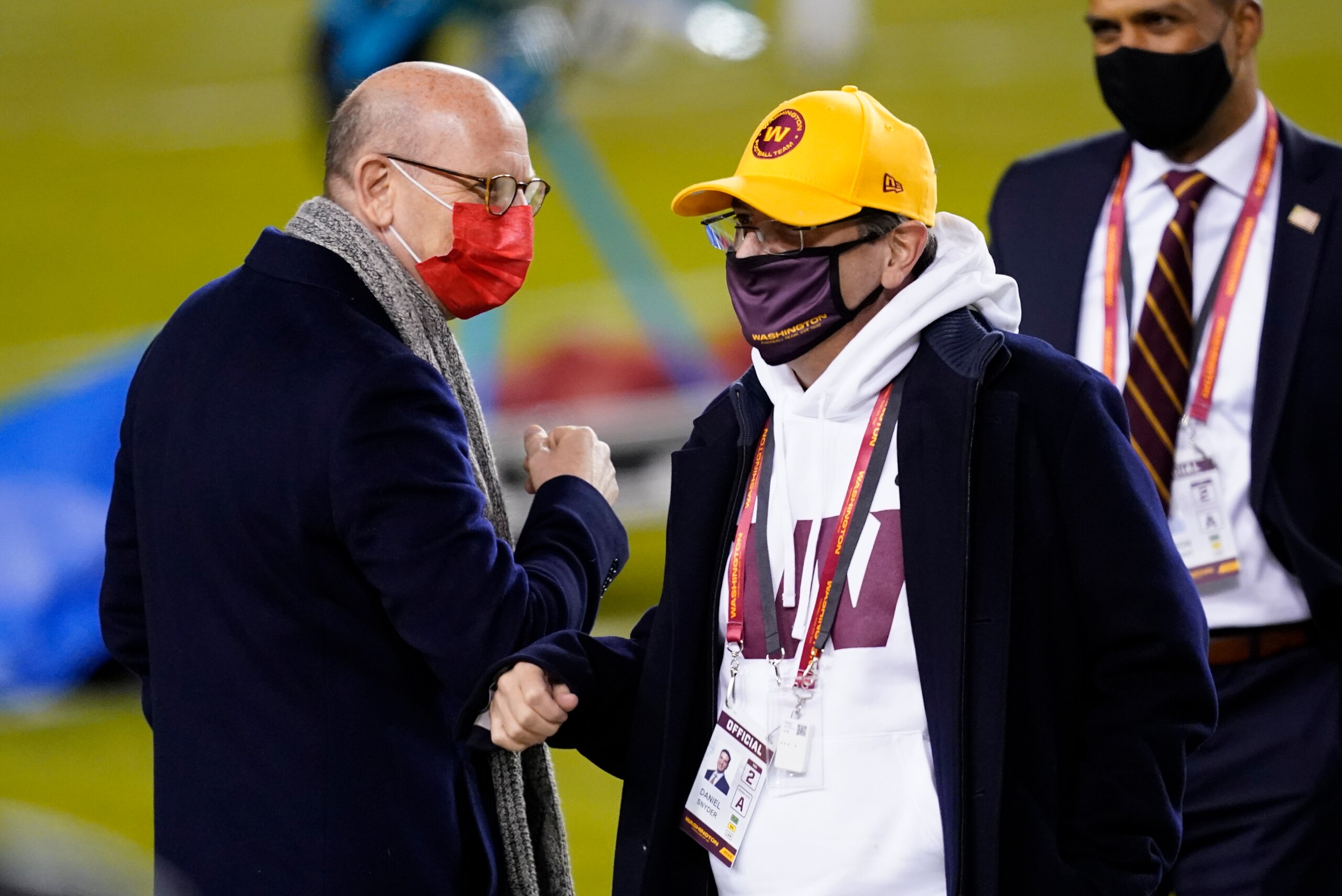 Tampa Bay Buccaneers owner Joel Glazer, left, talks with Washington Football Team owner Daniel Snyder, right, before an NFL wild-card playoff football game Saturday, Jan. 9, 2021, in Landover, Md. (AP Photo/Andrew Harnik)