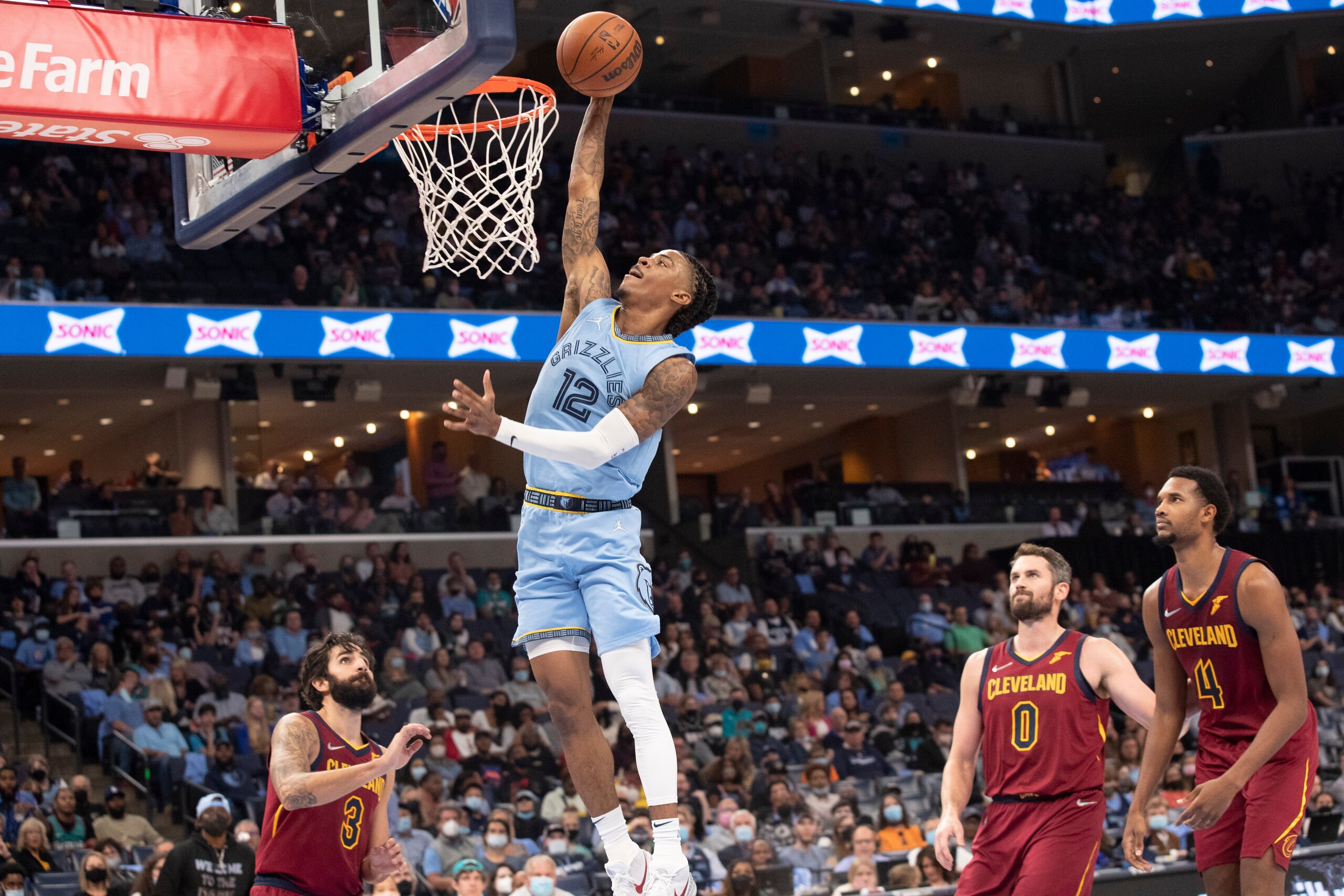 Memphis Grizzlies guard Ja Morant (12) goes to the basket as Cleveland Cavaliers guard Ricky Rubio (3), forward Kevin Love (0) and center Evan Mobley (4) watch during the second half of an NBA basketball game Wednesday, Oct. 20, 2021, in Memphis, Tenn. (AP Photo/Nikki Boertman)