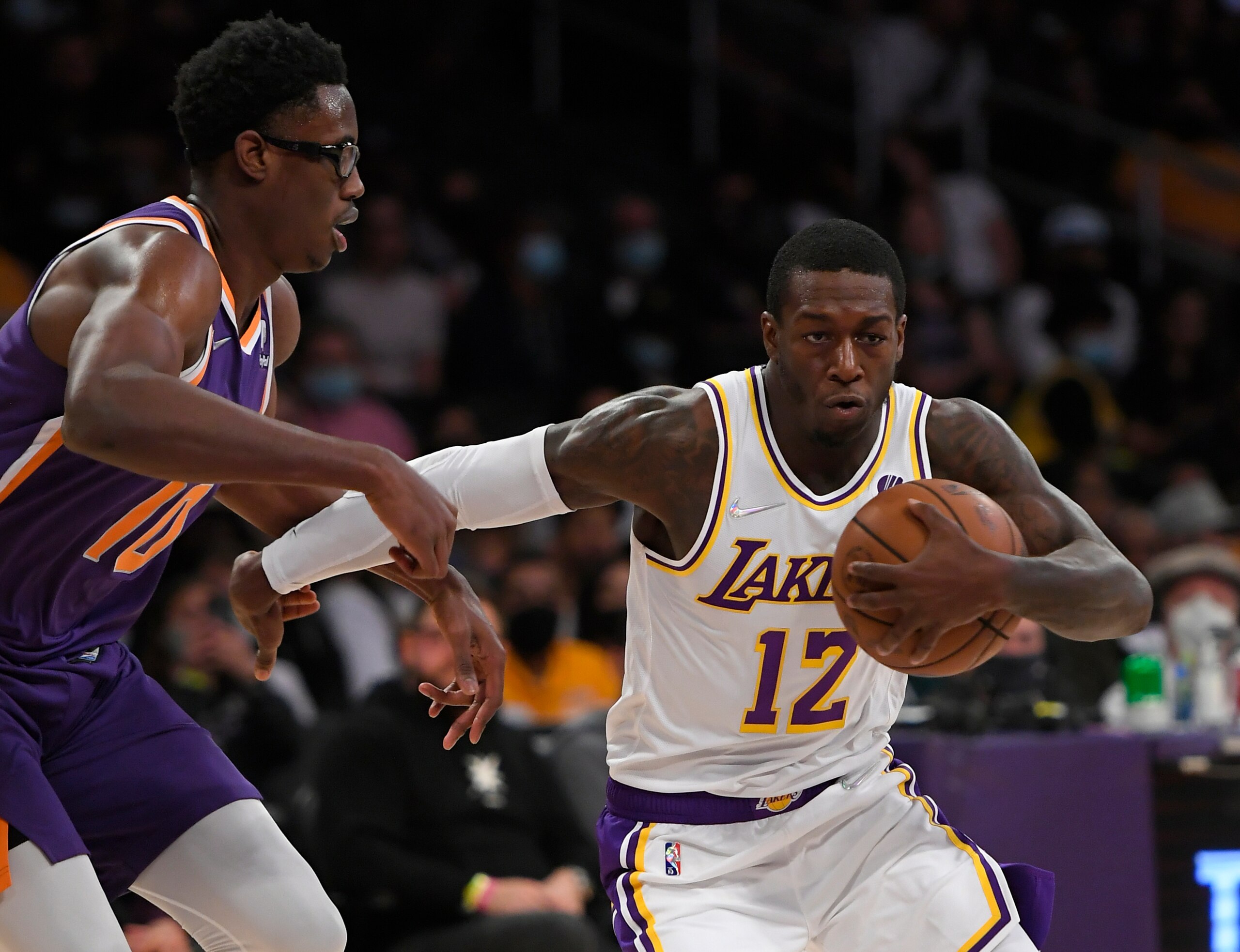 Los Angeles Lakers guard Kendrick Nunn (12) dribbles past Phoenix Suns forward Jalen Smith (10) in the second half of a preseason NBA basketball game in Los Angeles, Sunday, Oct. 10, 2021. (AP Photo/John McCoy)