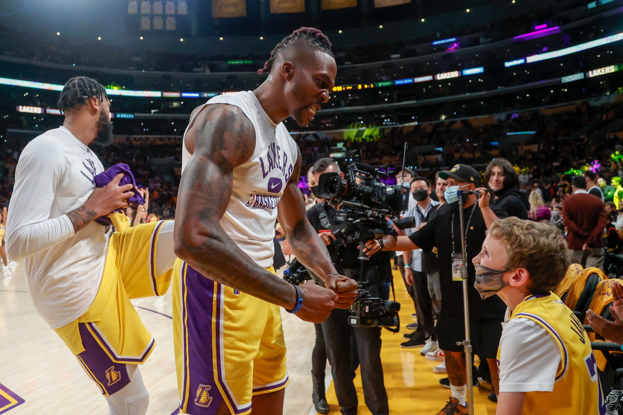 Los Angeles Lakers center Dwight Howard (39) interacts with a young fan before an NBA basketball game against the Golden State Warriors in Los Angeles, Tuesday, Oct. 19, 2021. (AP Photo/Ringo H.W. Chiu)