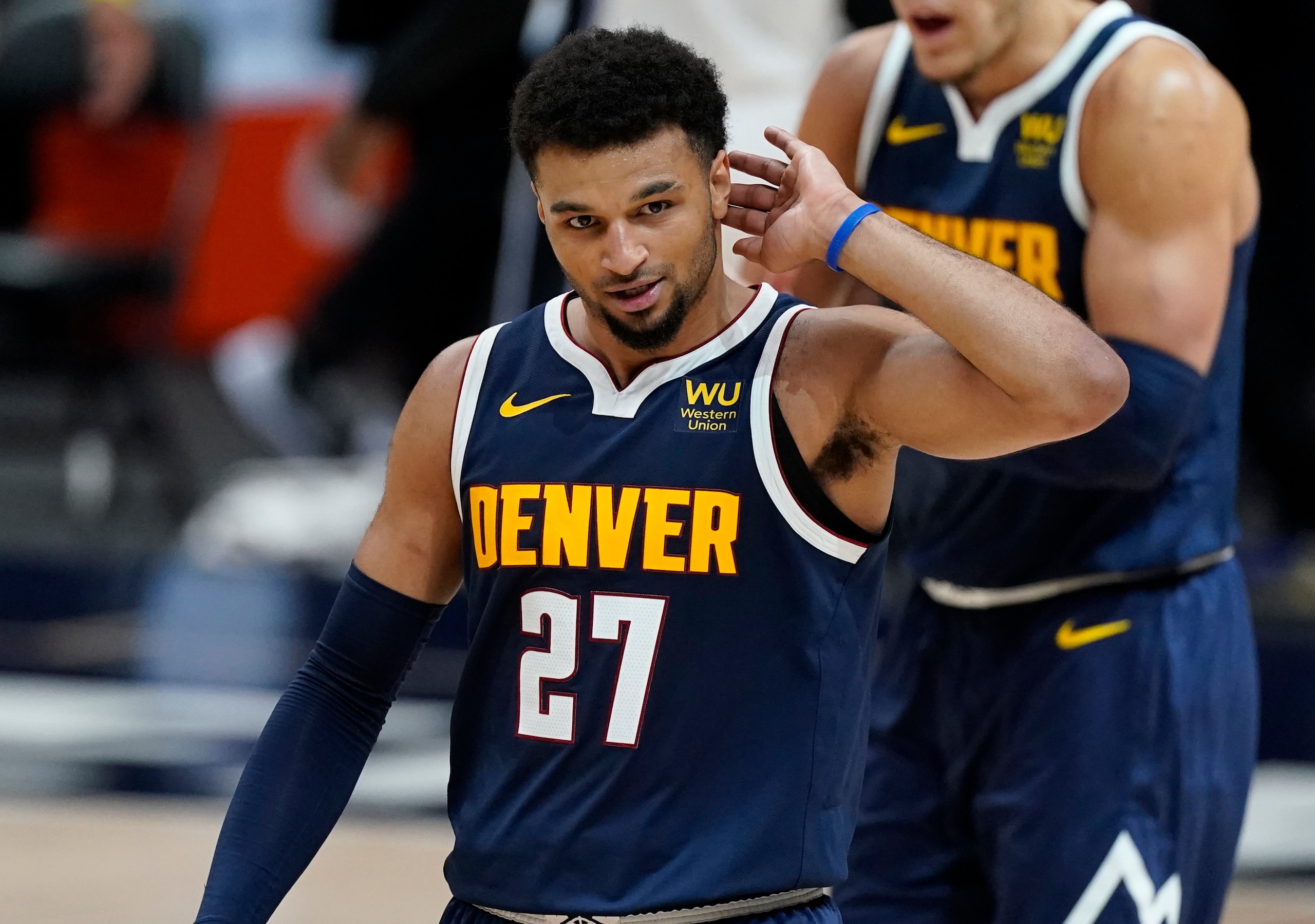 Denver Nuggets guard Jamal Murray cups his hand to hear the cheers after he hit a 3-point-basket against the Orlando Magic late in the second half of an NBA basketball game Sunday, April 4, 2021, in Denver. The Nuggets won 119-109. (AP Photo/David Zalubowski)