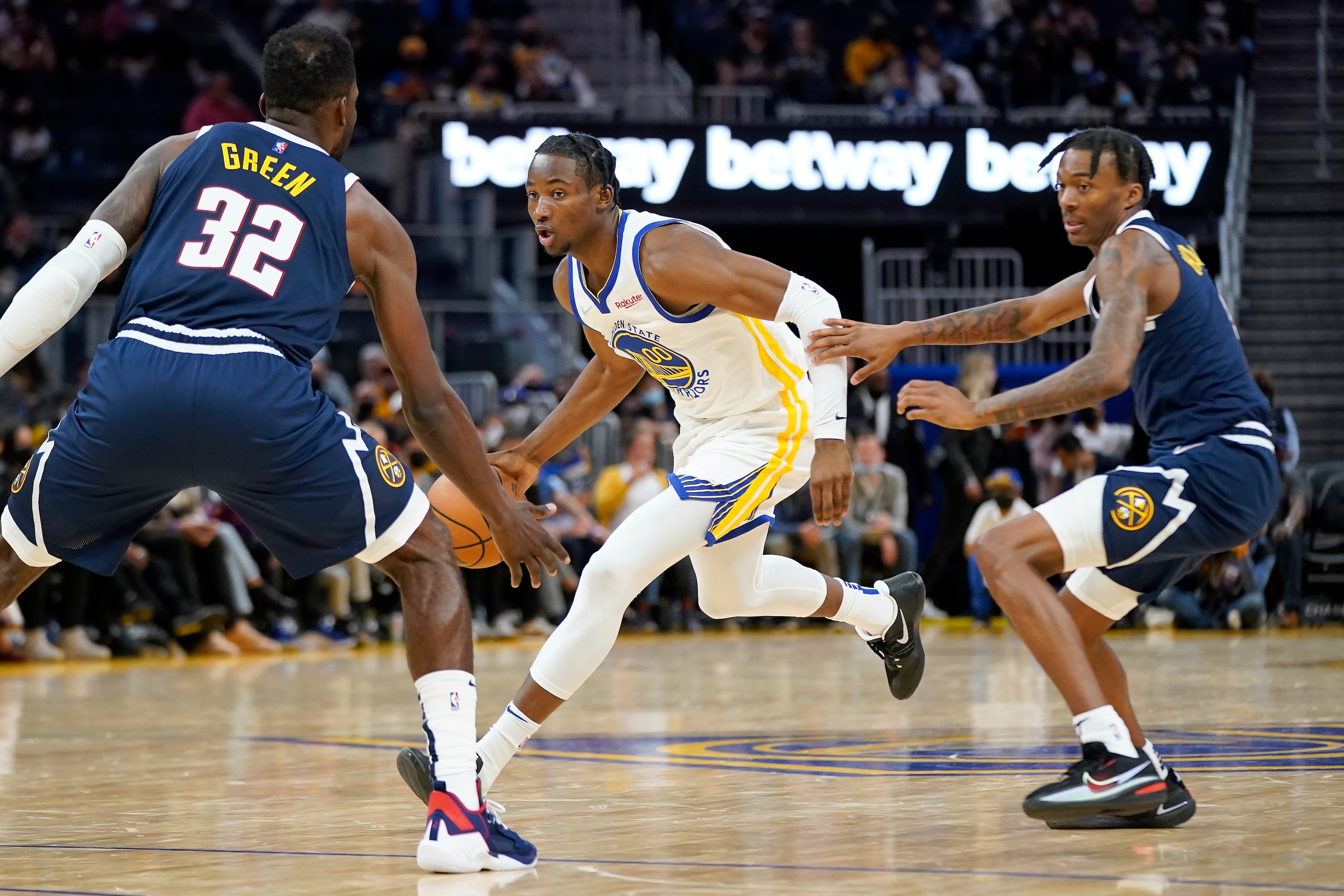 Golden State Warriors forward Jonathan Kuminga, middle, dribbles between Denver Nuggets forward Jeff Green (32) and guard Bones Hyland during a preseason NBA basketball game in San Francisco, Wednesday, Oct. 6, 2021. (AP Photo/Jeff Chiu)