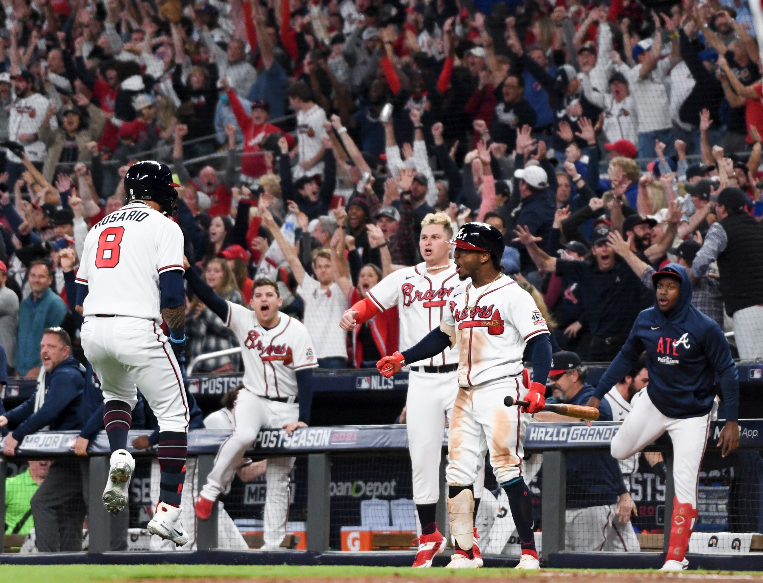 Atlanta, GA - October 23: Atlanta Braves' Eddie Rosario, from left, celebrates while approaching home off a three-run home run as Joc Pederson and Ozzie Albies wait during the fourth inning in game six in the 2021 National League Championship Series against the Los Angeles Dodgers at Truist Park on Saturday, Oct. 23, 2021 in Atlanta, GA. (Wally Skalij / Los Angeles Times via Getty Images)