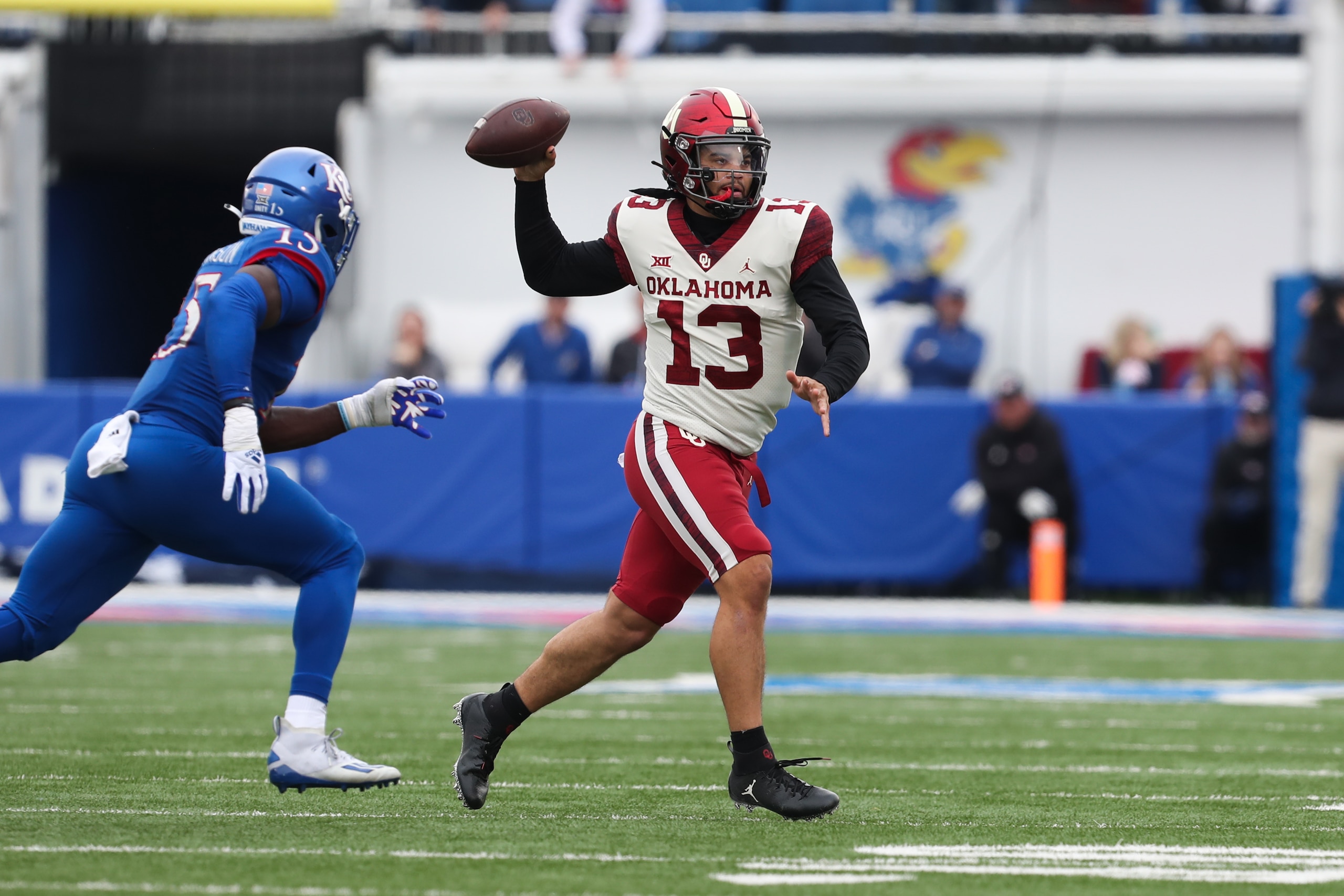 LAWRENCE, KS - OCTOBER 23: Oklahoma Sooners quarterback Caleb Williams (13) looks to pass while rolling out late in the second quarter of a Big 12 football game between the Oklahoma Sooners and Kansas Jayhawks on Oct 23, 2021 at Memorial Stadium in Lawrence, KS. (Photo by Scott Winters/Icon Sportswire via Getty Images)