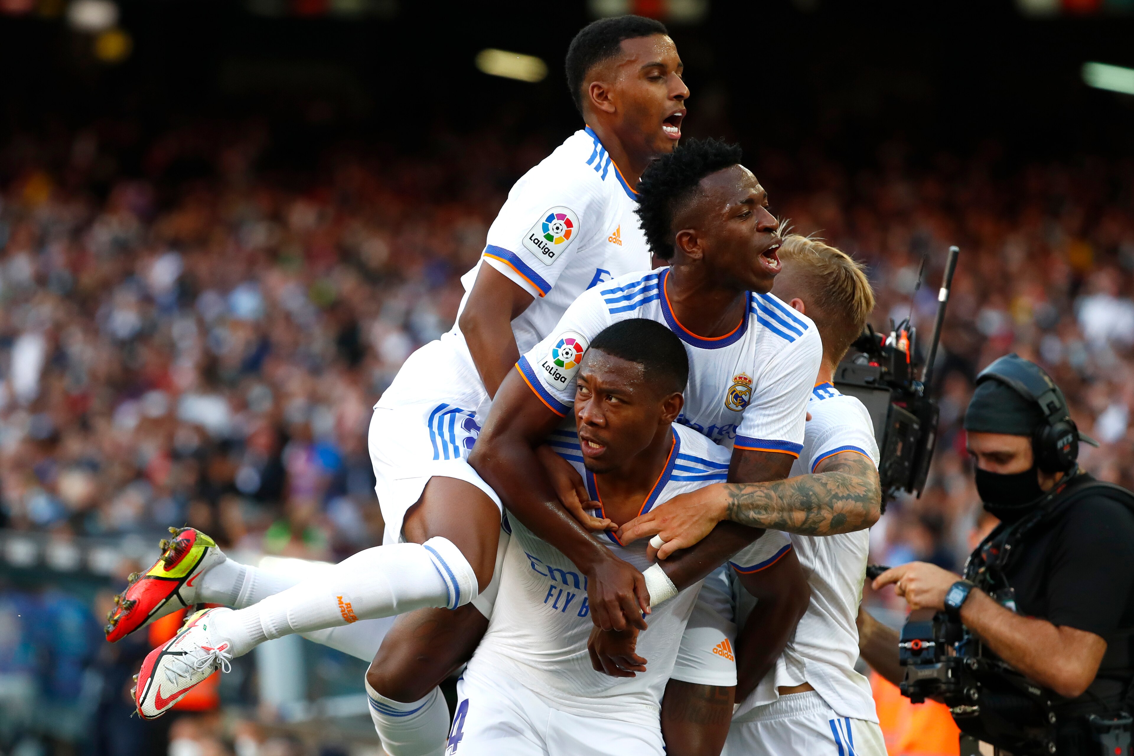 Real Madrid's David Alaba, down, celebrates with teammates after scoring his sides first goal during the Spanish La Liga soccer match between FC Barcelona and Real Madrid at the Camp Nou stadium in Barcelona, Spain, Sunday, Oct. 24, 2021. (AP Photo/Joan Monfort)