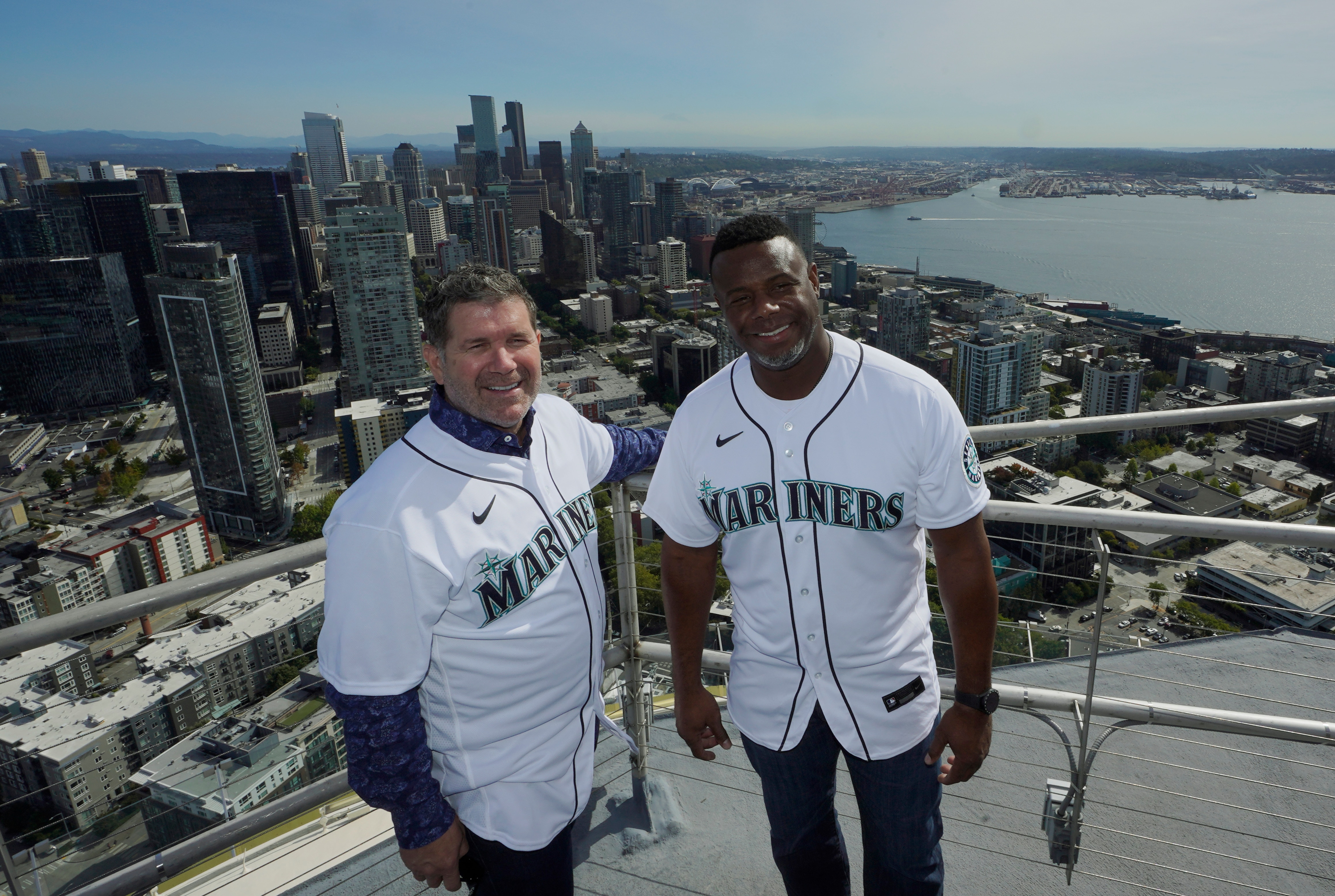 Former Seattle Mariners players Edgar Martinez, left, and Ken Griffey Jr., right, pose for a photo after they raised a flag for the 2023 MLB All-Star Game on the roof of the Space Needle, Thursday, Sept. 16, 2021, in Seattle. Earlier in the day, MLB Commissioner Rob Manfred announced that the Mariners will host the 2023 MLB All-Star Game at T-Mobile Park. (AP Photo/Ted S. Warren)