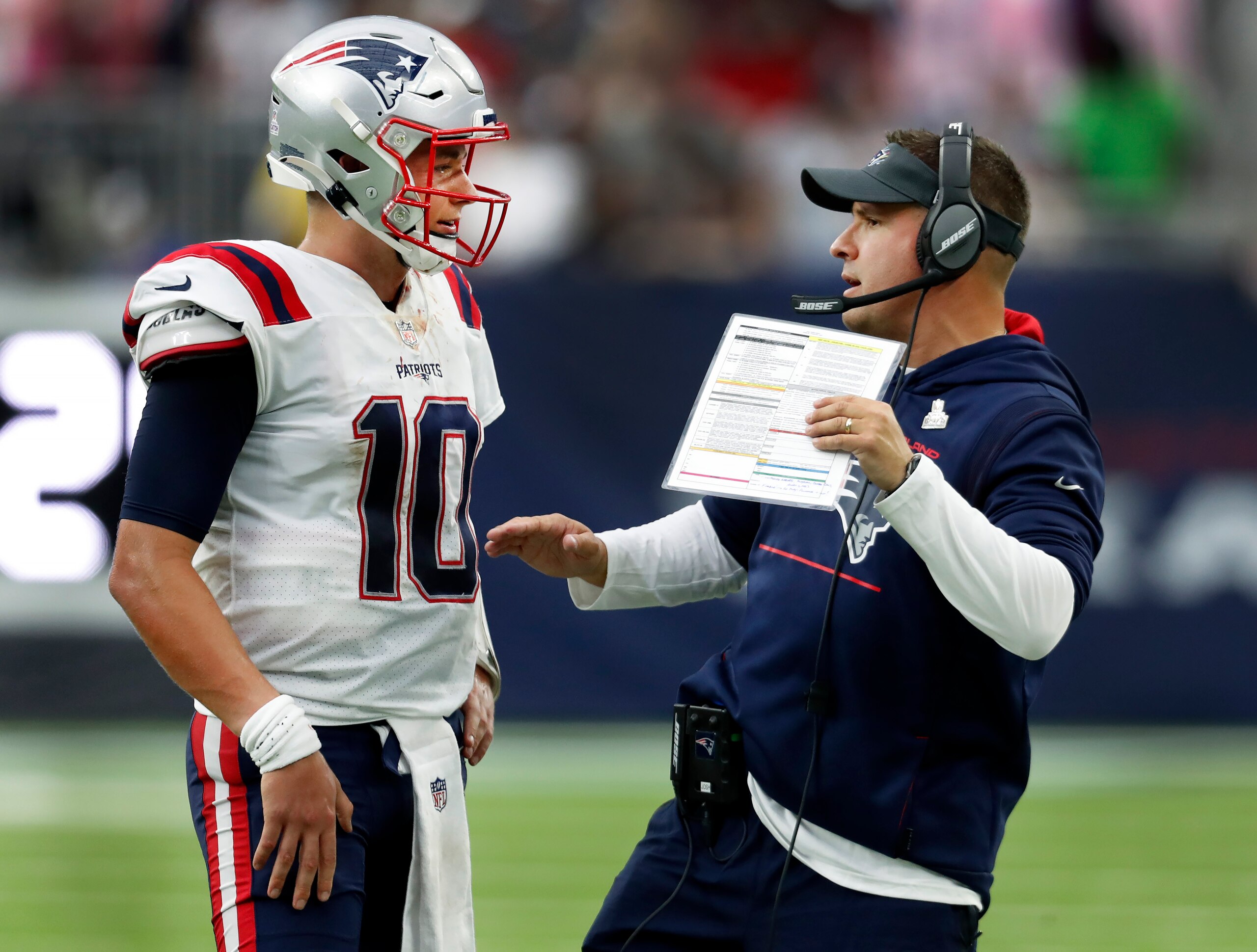 Houston, TX - October 10: During the last New England drive of the game, quarterback Mac Jones (left) came to the sidelines to confer with offensive coordinator Josh McDaniels (right).  The New England Patriots visited the Houston Texans for a regular season NFL football game at NRG Stadium in Houston, TX on Oct. 10, 2021. (Photo by Jim Davis/The Boston Globe via Getty Images)