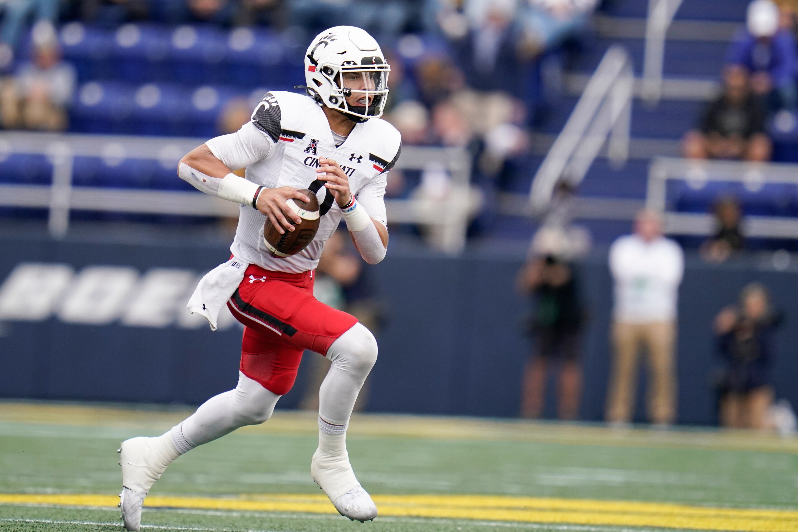 Cincinnati quarterback Desmond Ridder scrambles against Navy during the second half of an NCAA college football game, Saturday, Oct. 23, 2021, in Annapolis, Md. Cincinnati won 27-20. (AP Photo/Julio Cortez) Cincinnati quarterback Desmond Ridder scrambles against Navy during the second half of an NCAA college football game, Saturday, Oct. 23, 2021, in Annapolis, Md. Cincinnati won 27-20. (AP Photo/Julio Cortez)