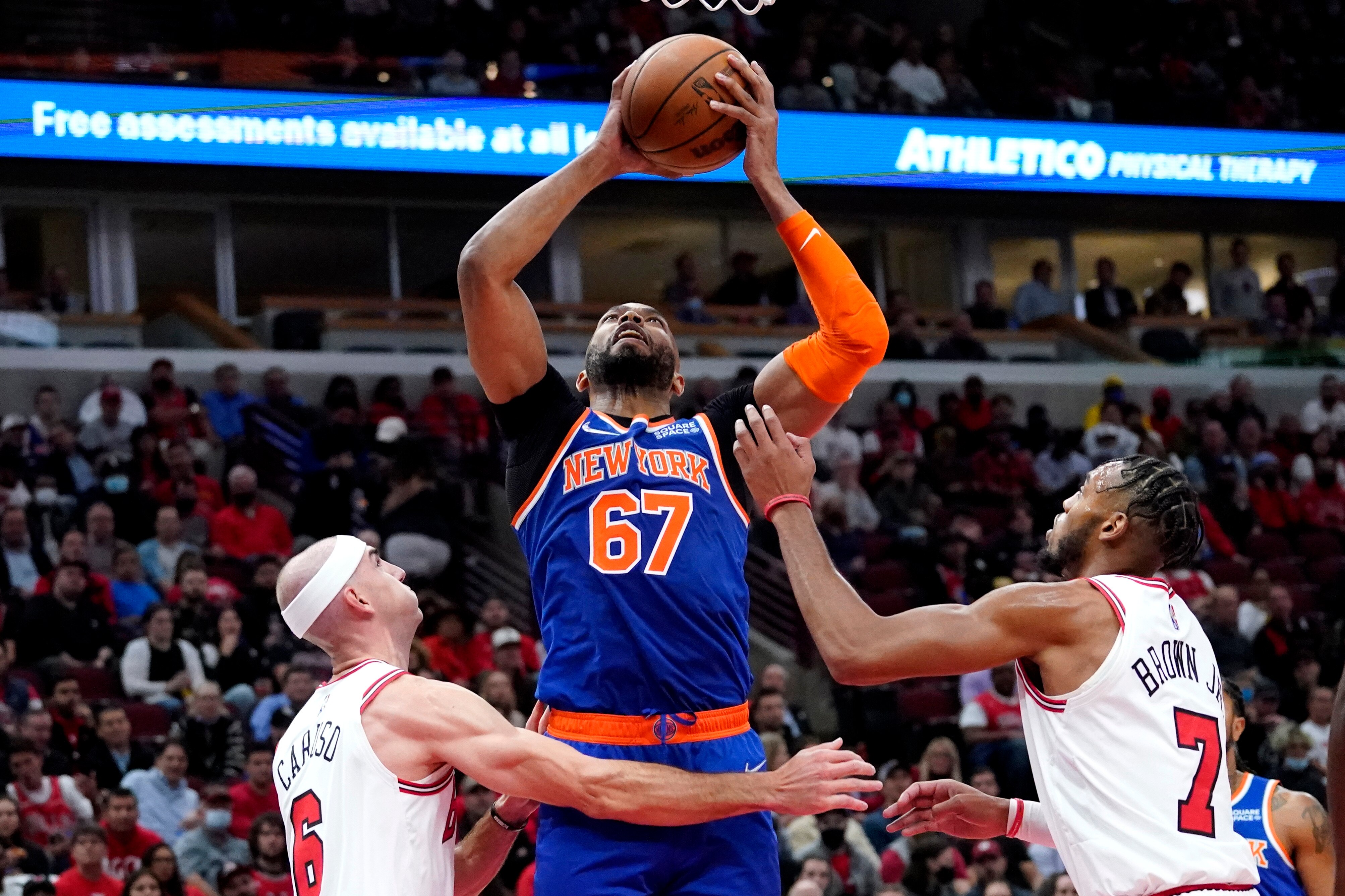New York Knicks center Taj Gibson, center, rebounds the ball against Chicago Bulls guard Alex Caruso, left, and forward Troy Brown Jr. during the first half of an NBA basketball game Thursday, Oct. 28, 2021, in Chicago. (AP Photo/Nam Y. Huh) New York Knicks center Taj Gibson, center, rebounds the ball against Chicago Bulls guard Alex Caruso, left, and forward Troy Brown Jr. during the first half of an NBA basketball game Thursday, Oct. 28, 2021, in Chicago. (AP Photo/Nam Y. Huh)