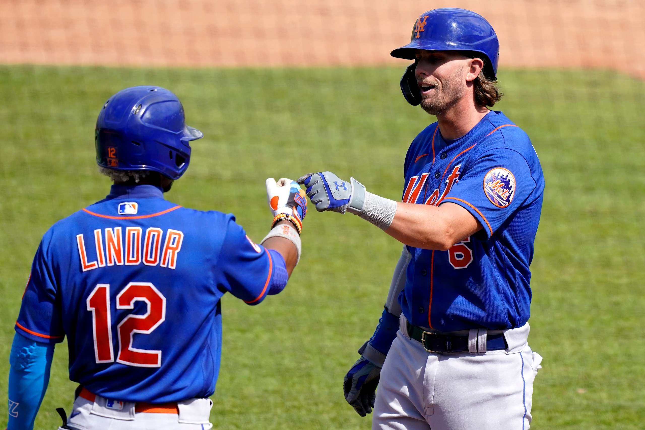 New York Mets' Francisco Lindor (12)greets Jeff McNeil (6) after McNeil scored on a double hit by Mallex Smith during the sixth inning of a spring training baseball game against the Washington Nationals, Sunday, March 21, 2021, in West Palm Beach, Fla. (AP Photo/Lynne Sladky)