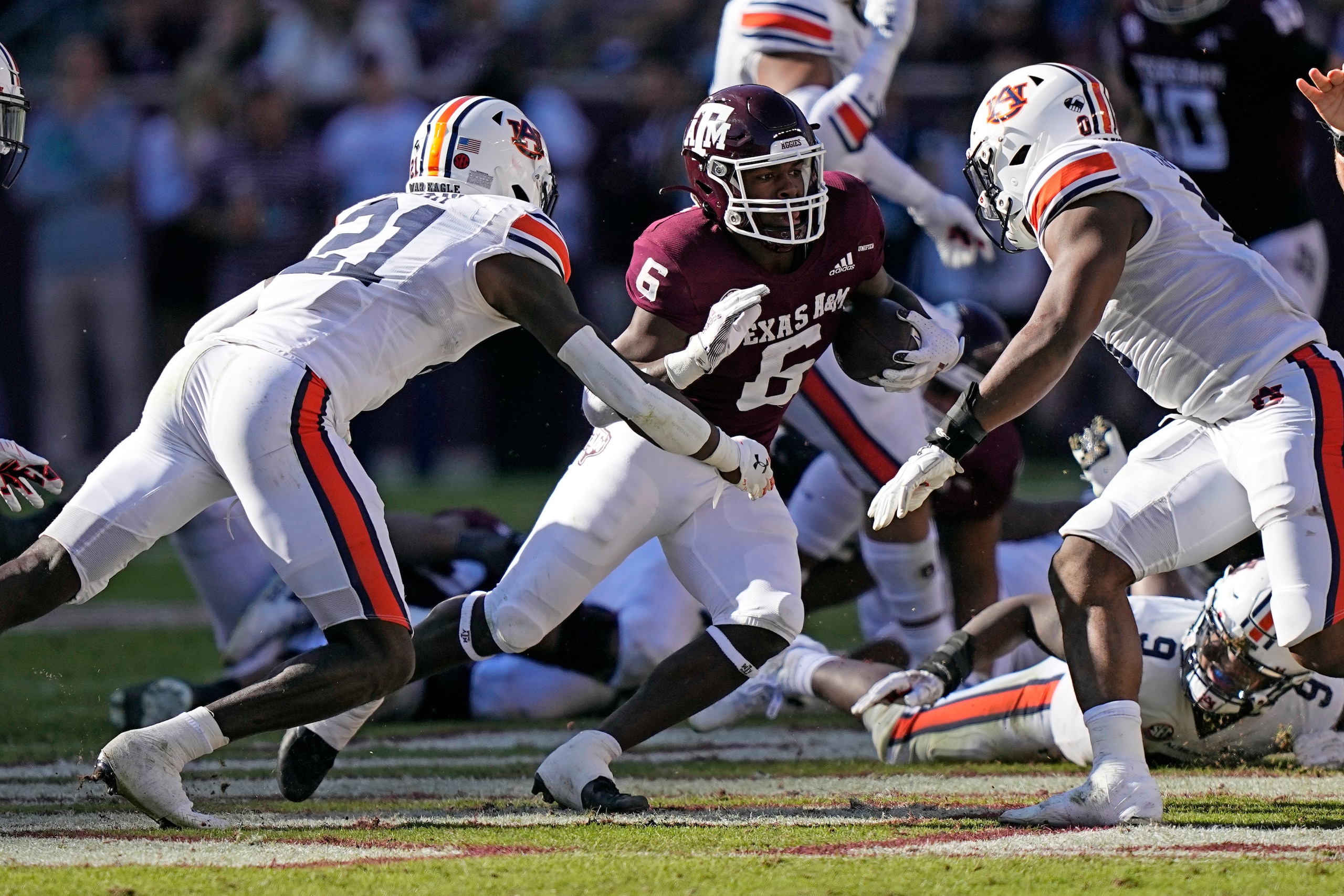 Texas A&M running back Devon Achane (6) runs for a gain as Auburn's Smoke Monday (21) and Owen Pappoe (0) defend during the first half of an NCAA college football game Saturday, Nov. 6, 2021, in College Station, Texas. (AP Photo/David J. Phillip)