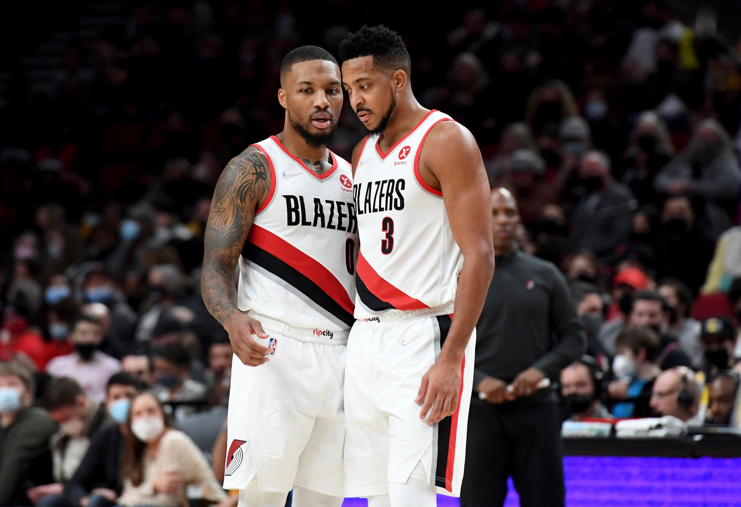Portland Trail Blazers guard Damian Lillard, left, speaks with guard CJ McCollum during the second half of the team's NBA basketball game against the Los Angeles Lakers in Portland, Ore., Saturday, Nov. 6, 2021. The Blazers won 105-90. (AP Photo/Steve Dykes)