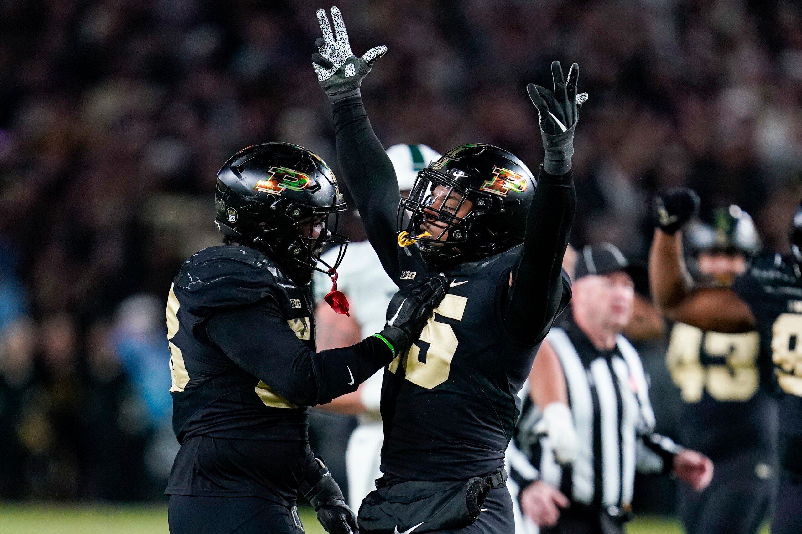 Purdue defensive end DaMarcus Mitchell (15) celebrates a sack with defensive tackle Branson Deen (58) during the second half of an NCAA college football game against Michigan State in West Lafayette, Ind., Saturday, Nov. 6, 2021. (AP Photo/Michael Conroy)