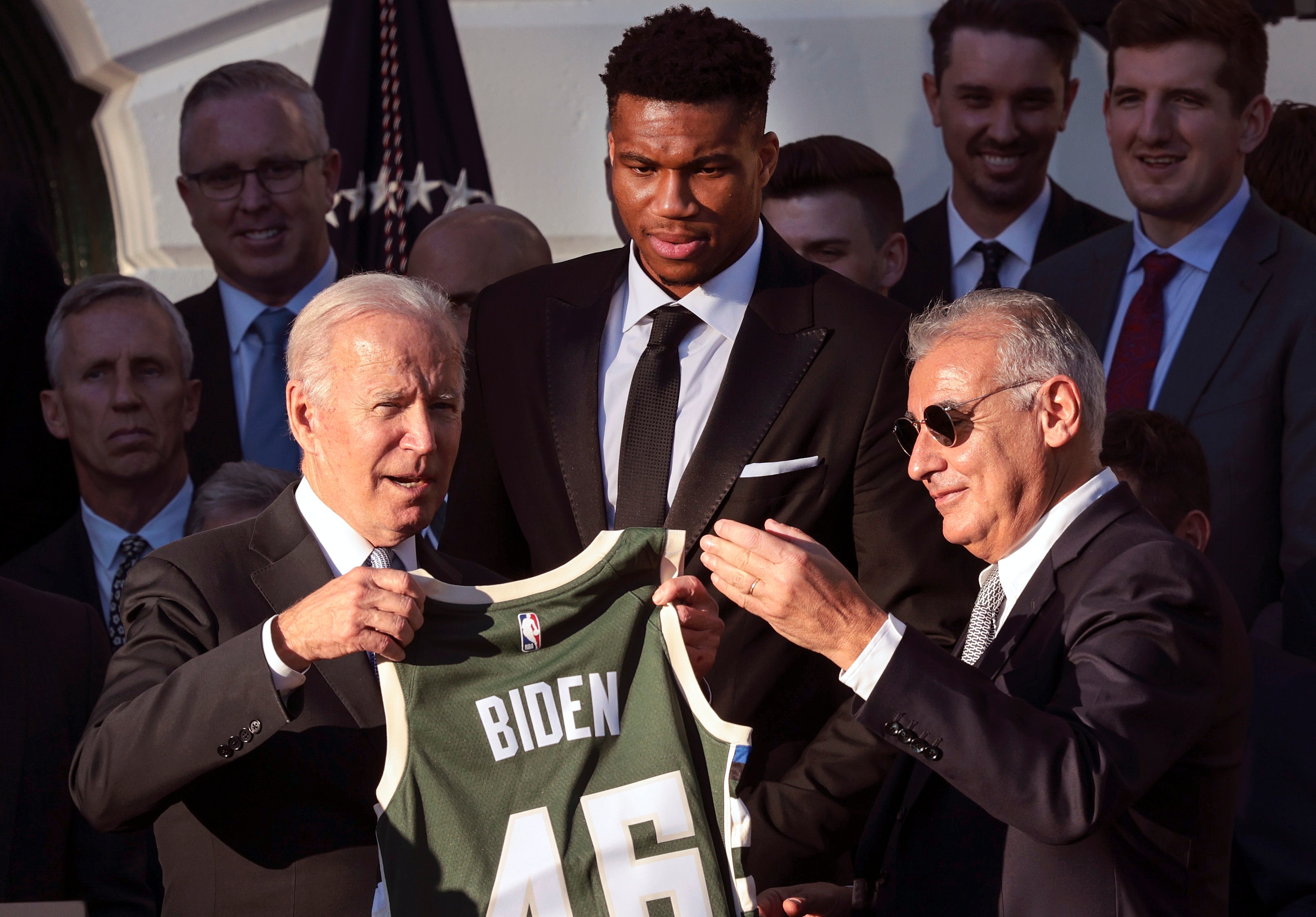 WASHINGTON, DC - NOVEMBER 08: U.S. President Joe Biden (L) receive a jersey from Milwaukee Bucks owner Marc Lasry (R) as player Giannis Antetokounmpo (C) watches during an event where Biden honored the Bucks for winning the 2021 NBA Championship, on the South Lawn at the White House on November 08, 2021 in Washington, DC. The Bucks defeated the Phoenix Suns to win the 2021 NBA Championship. (Photo by Win McNamee/Getty Images)