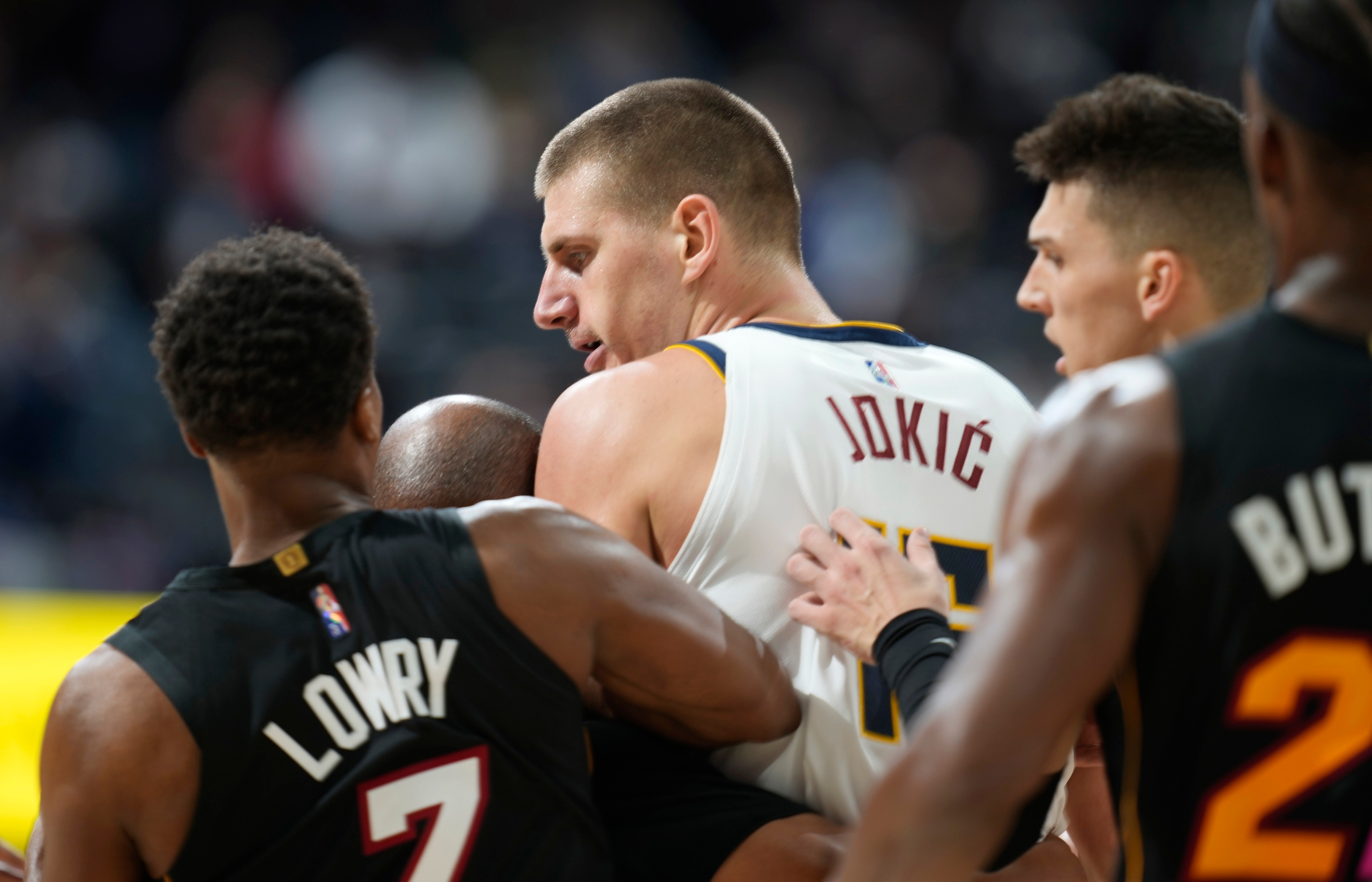 Denver Nuggets center Nikola Jokic, center, is restrained by Miami Heat guards Kyle Lowry, left, and Tyler Herro after knocking over Heat forward Markieff Morris during a scrum in the second half of an NBA basketball game Monday, Nov. 8, 2021, in Denver. Jokic was ejected, Morris assessed a personal foul for his part in the altercation. (AP Photo/David Zalubowski)