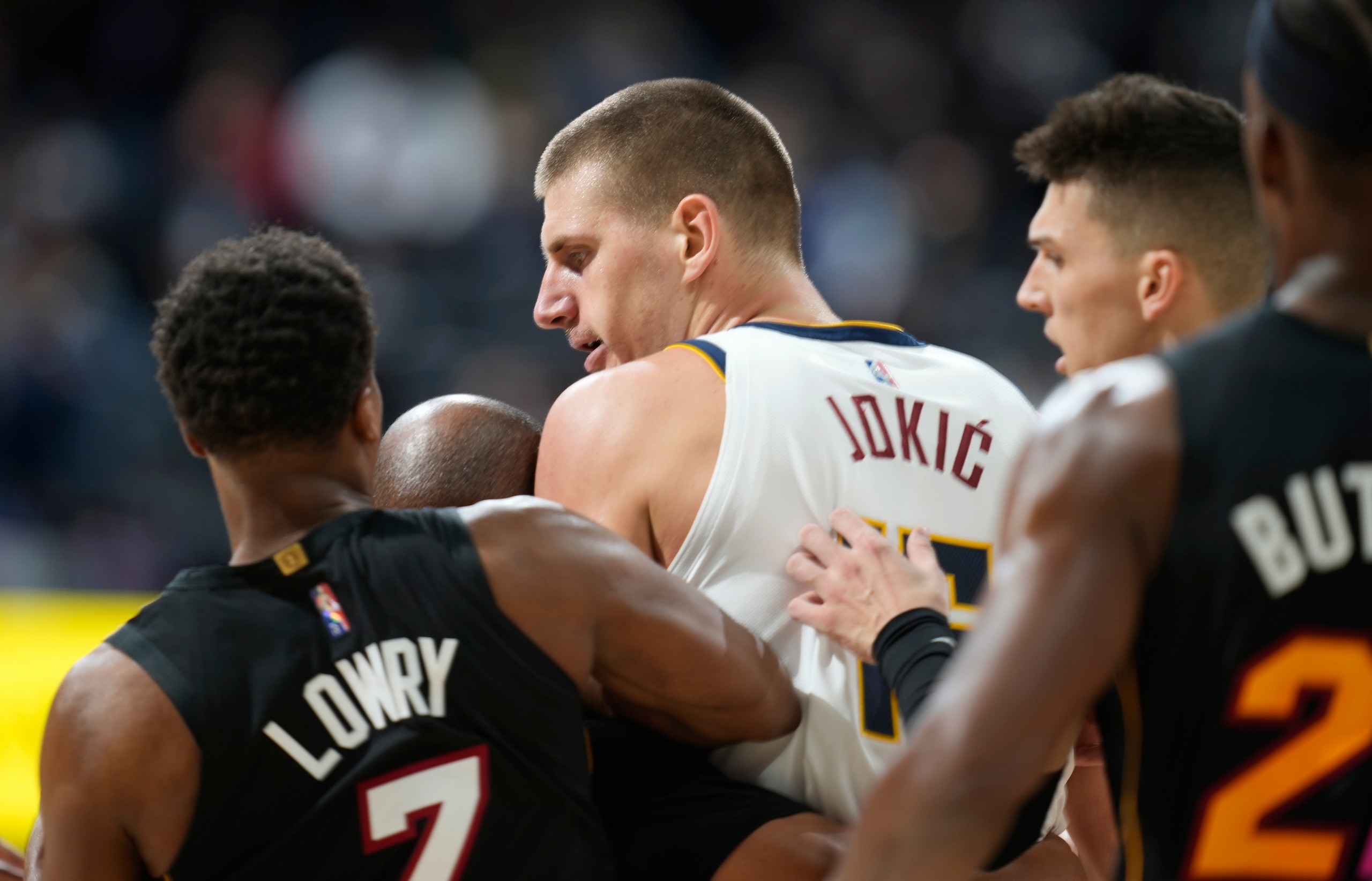 Denver Nuggets center Nikola Jokic, center, is restrained by Miami Heat guards Kyle Lowry, left, and Tyler Herro after knocking over Heat forward Markieff Morris during a scrum in the second half of an NBA basketball game Monday, Nov. 8, 2021, in Denver. Jokic was ejected, Morris assessed a personal foul for his part in the altercation. (AP Photo/David Zalubowski)