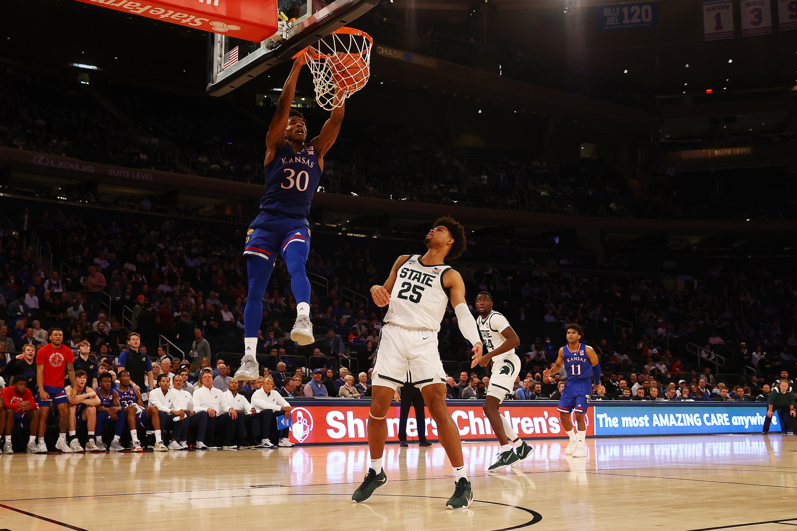 NEW YORK, NEW YORK - NOVEMBER 09: Ochai Agbaji #30 of the Kansas Jayhawks dunks the ball against Malik Hall #25 of the Michigan State Spartans during the State Farm Champions Classic at Madison Square Garden on November 09, 2021 in New York City. (Photo by Mike Stobe/Getty Images)