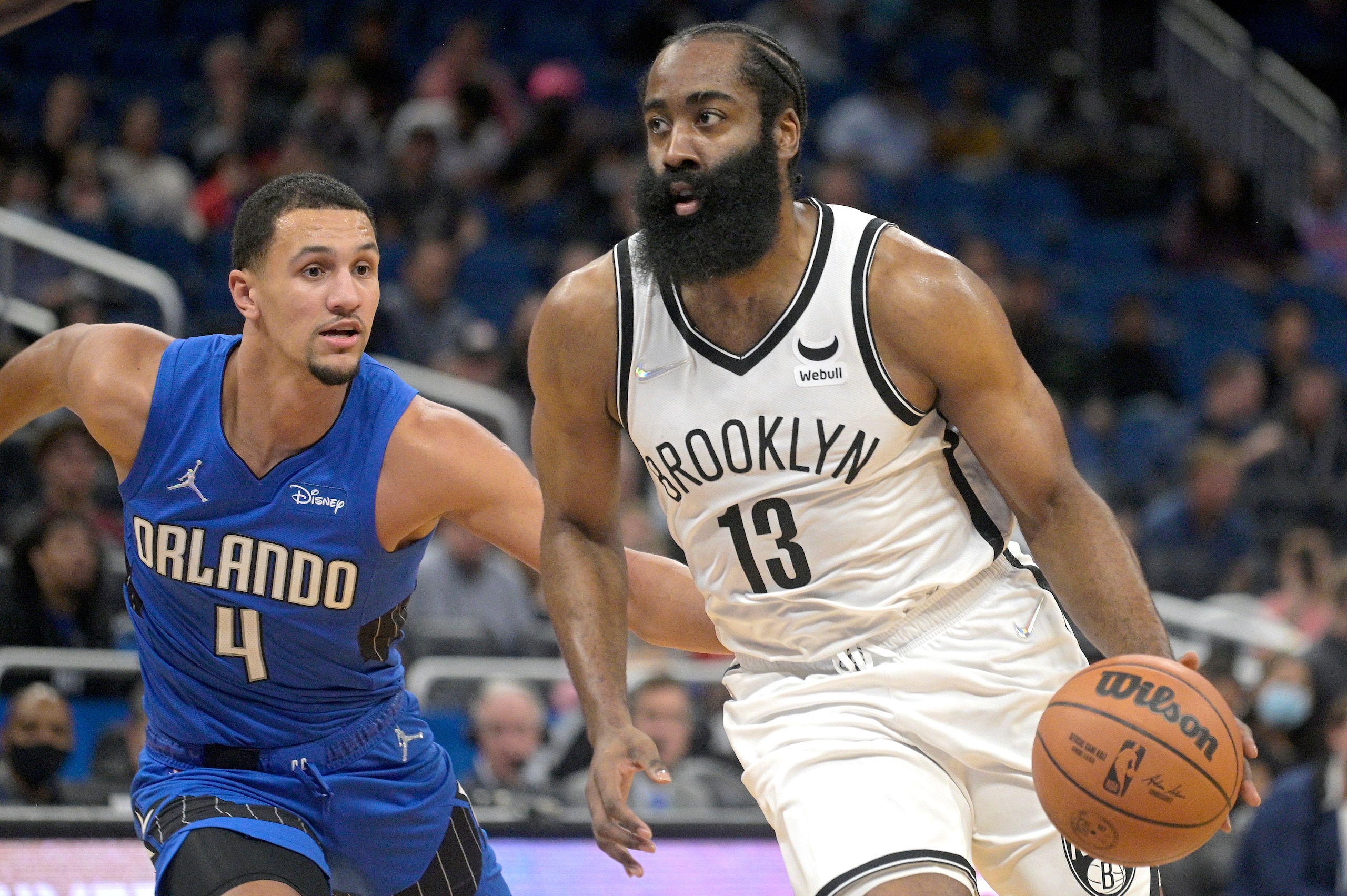 Brooklyn Nets guard James Harden (13) drives to the basket in front of Orlando Magic guard Jalen Suggs (4) during the first half of an NBA basketball game Wednesday, Nov. 10, 2021, in Orlando, Fla. (AP Photo/Phelan M. Ebenhack)