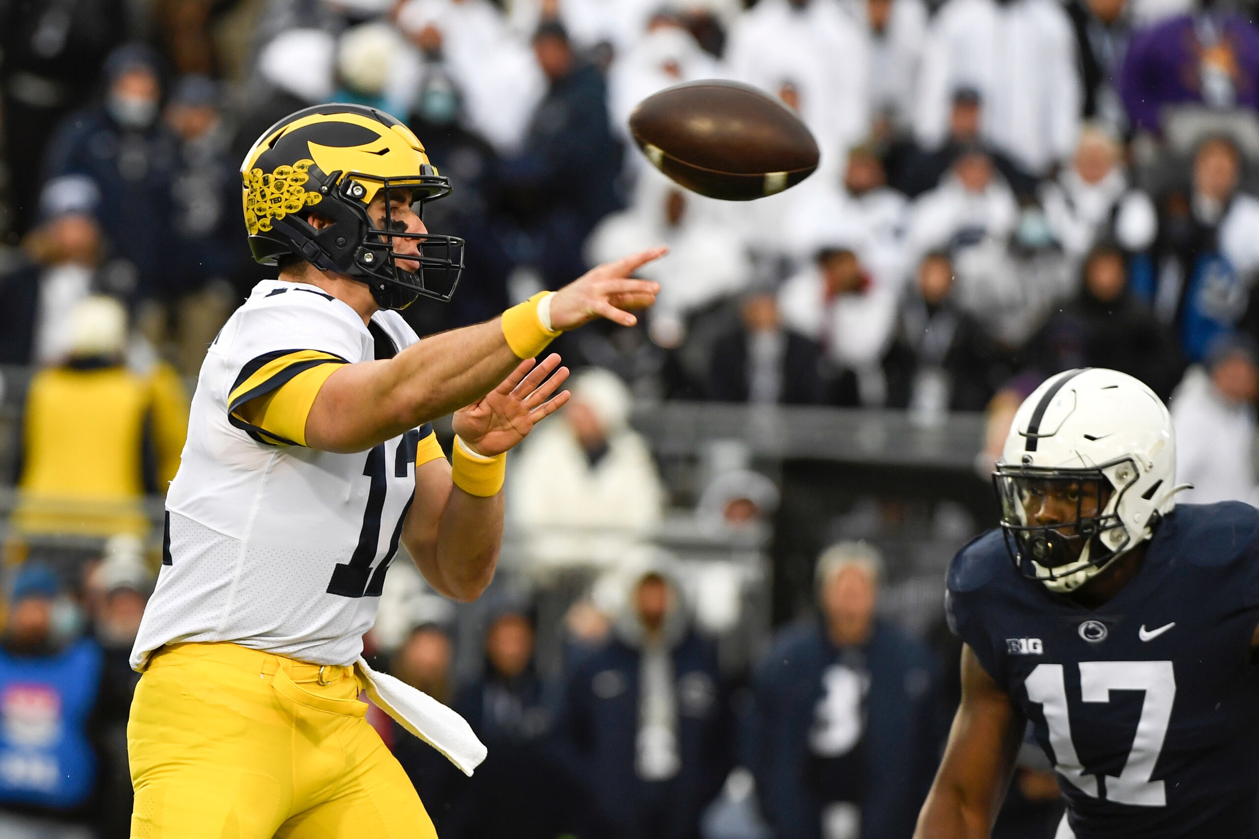 Michigan quarterback Cade McNamara (12) passes while being pressured by Penn State defensive end Arnold Ebiketie (17) in the first quarter of an NCAA college football game in State College, Pa., Saturday, Nov. 13, 2021. (AP Photo/Barry Reeger)