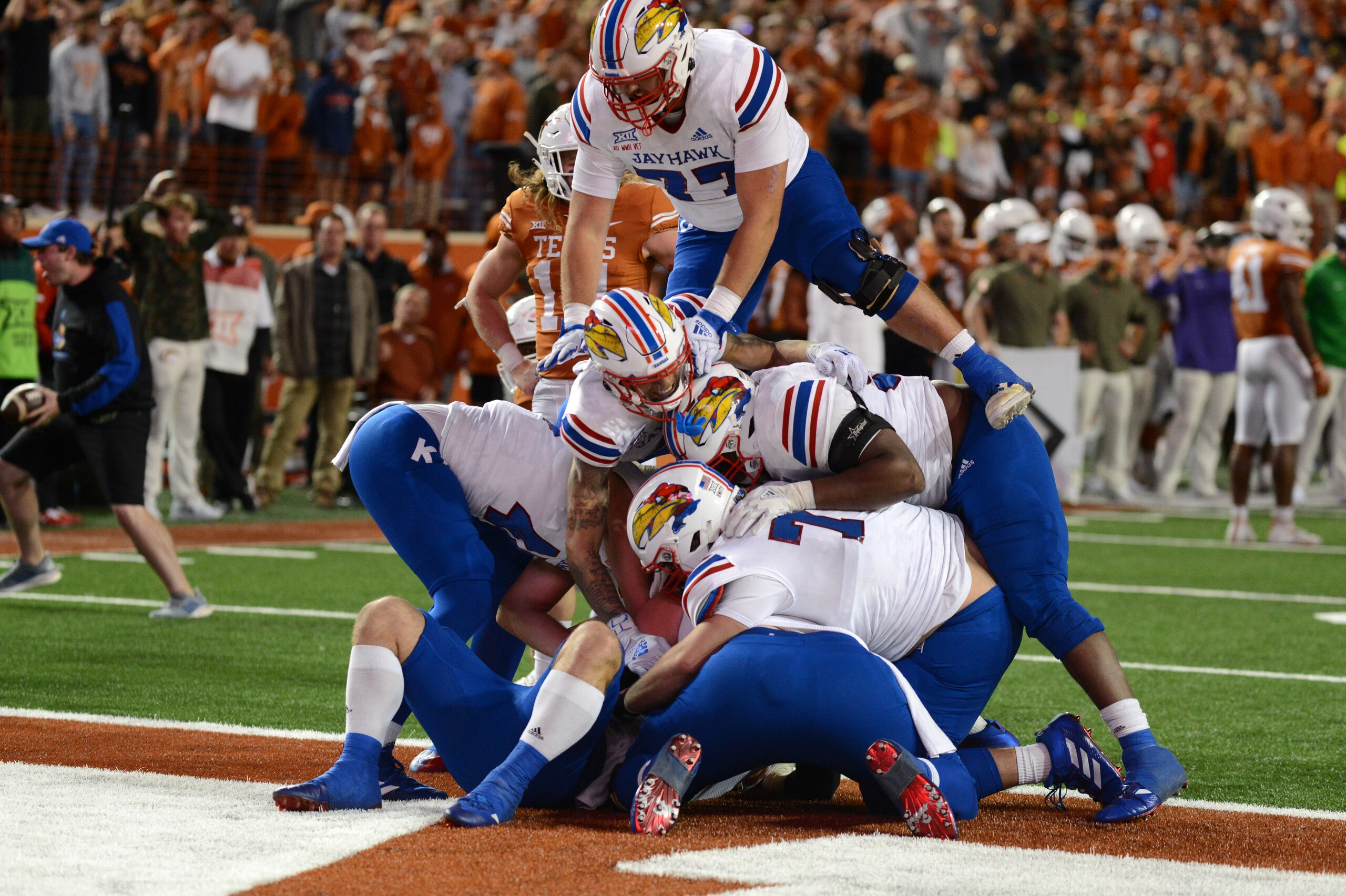 AUSTIN, TX - NOVEMBER 13: Kansas Jayhawks players dog pile on Jared Casey after scoring the winning two-point conversion during game between the Kansas Jayhawks and the Texas Longhorns on November 13, 2021 at Darrell K Royal-Texas Memorial Stadium in Austin, TX. (Photo by John Rivera/Icon Sportswire via Getty Images) AUSTIN, TX - NOVEMBER 13: Kansas Jayhawks players dog pile on Jared Casey after scoring the winning two-point conversion during game between the Kansas Jayhawks and the Texas Longhorns on November 13, 2021 at Darrell K Royal-Texas Memorial Stadium in Austin, TX. (Photo by John Rivera/Icon Sportswire via Getty Images)