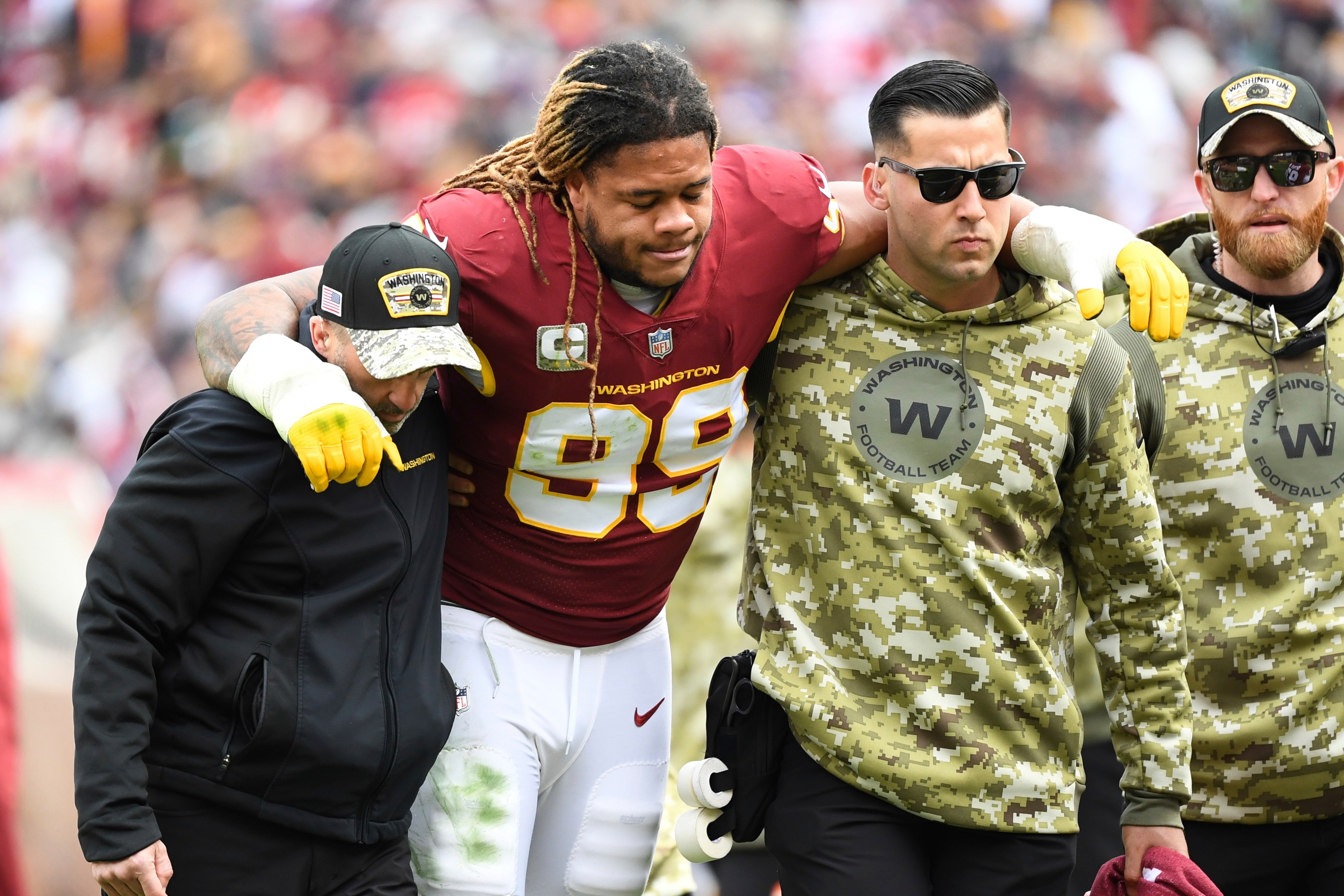 Washington Football Team defensive end Chase Young (99) is helped off the field after an apparent leg injury during the first half of an NFL football game against the Tampa Bay Buccaneers, Sunday, Nov. 14, 2021, in Landover, Md. (AP Photo/Terrance Williams)