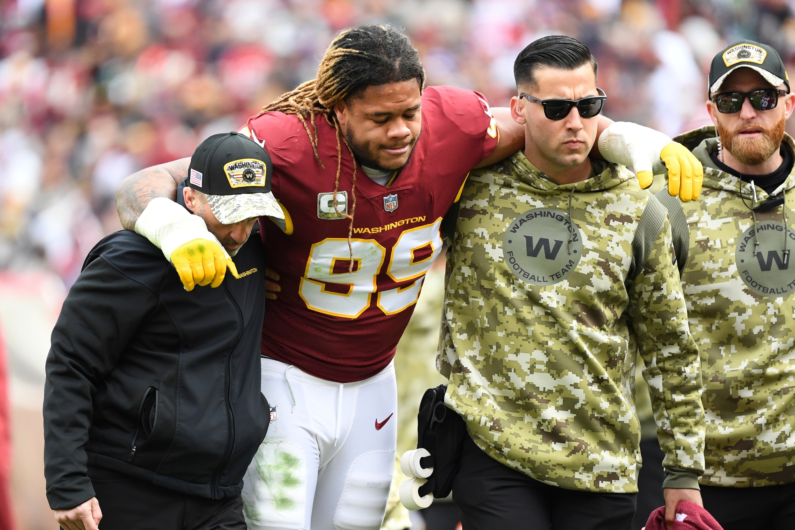 Washington Football Team defensive end Chase Young (99) is helped off the field after an apparent leg injury during the first half of an NFL football game against the Tampa Bay Buccaneers, Sunday, Nov. 14, 2021, in Landover, Md. (AP Photo/Terrance Williams)