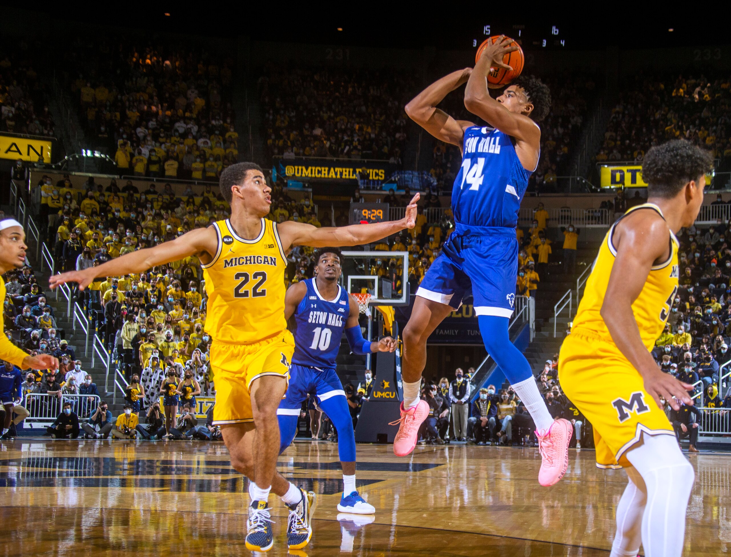 Michigan guard Caleb Houstan (22) defends against a jump shot from Seton Hall guard Jared Rhoden (14) during the first half of an NCAA college basketball game in Ann Arbor, Mich., Tuesday, Nov. 16, 2021. (AP Photo/Tony Ding)