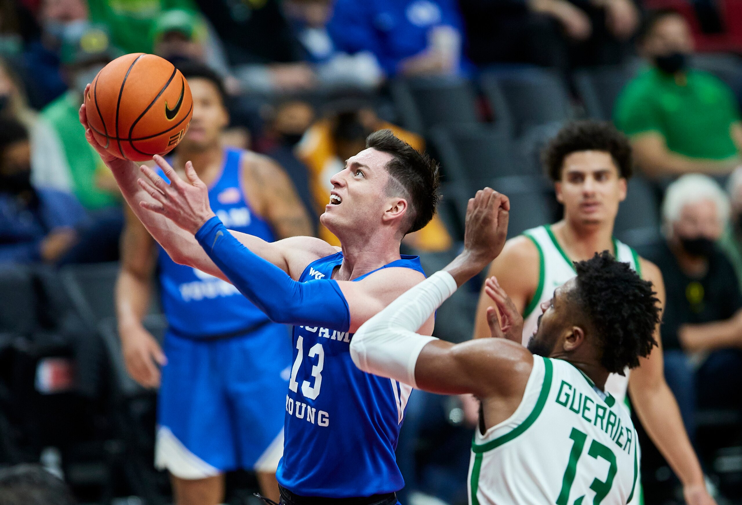 BYU guard Alex Barcello, left, shoots next to Oregon forward Quincy Guerrier during the second half of an NCAA college basketball game in Portland, Ore., Tuesday, Nov. 16, 2021. (AP Photo/Craig Mitchelldyer)