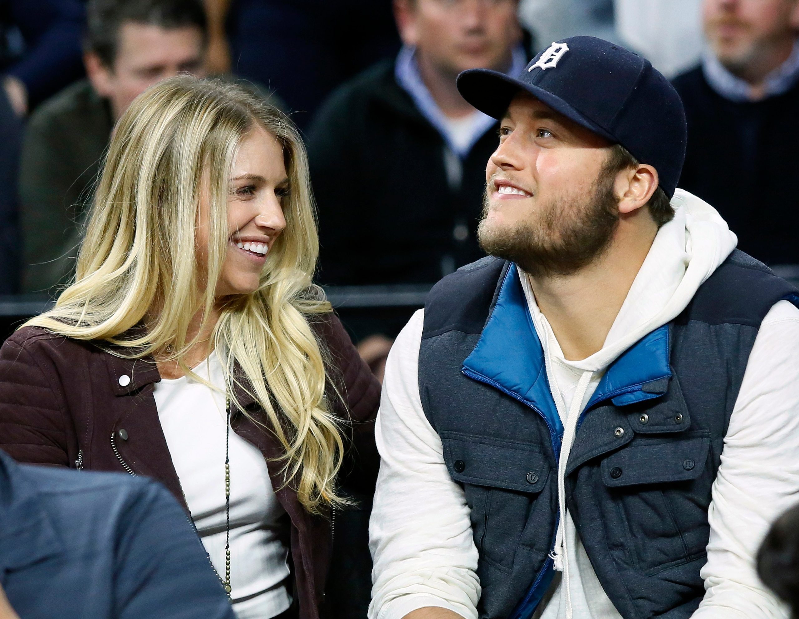 FILE - In this Nov. 17, 2015, file photo, Detroit Lions quarterback Matthew Stafford, right, smiles while watching the Detroit Pistons play the Cleveland Cavaliers with his wife Kelly, left, during the first half of an NBA basketball game, in Auburn Hills, Mich. Kelly Stafford plans to have surgery to remove a brain tumor. Stafford shared the details Wednesday, April 3, 2019, on her Instagram account. She says an MRI showed the tumor on cranial nerves after she had vertigo spells within the last year. (AP Photo/Duane Burleson, File)