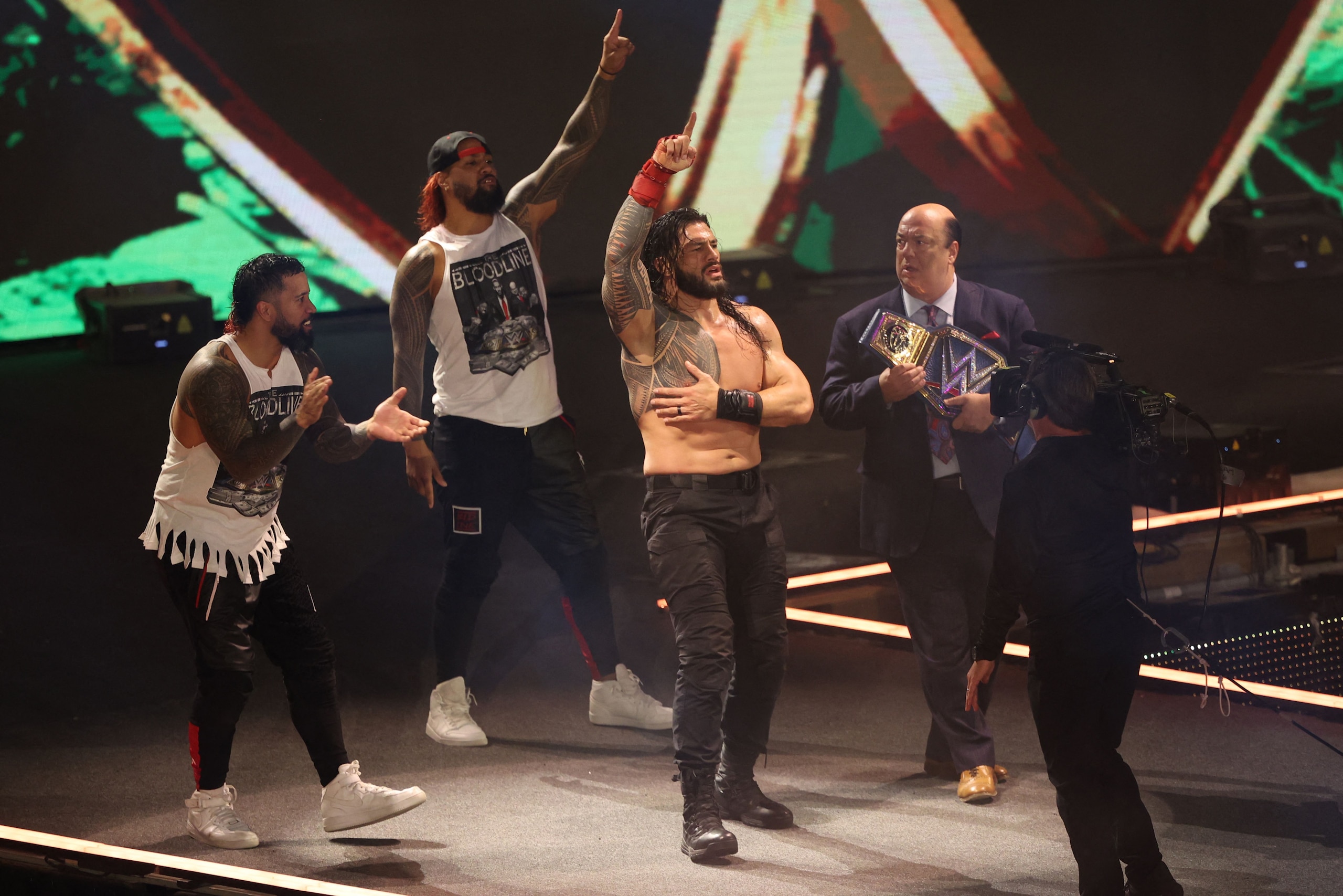 Roman Reigns (2nd-R) celebrates his win during the World Wrestling Entertainment (WWE) Crown Jewel pay-per-view in the Saudi capital Riyadh on October 21, 2021. (Photo by Fayez Nureldine / AFP) (Photo by FAYEZ NURELDINE/AFP via Getty Images) Roman Reigns (2nd-R) celebrates his win during the World Wrestling Entertainment (WWE) Crown Jewel pay-per-view in the Saudi capital Riyadh on October 21, 2021. (Photo by Fayez Nureldine / AFP) (Photo by FAYEZ NURELDINE/AFP via Getty Images)