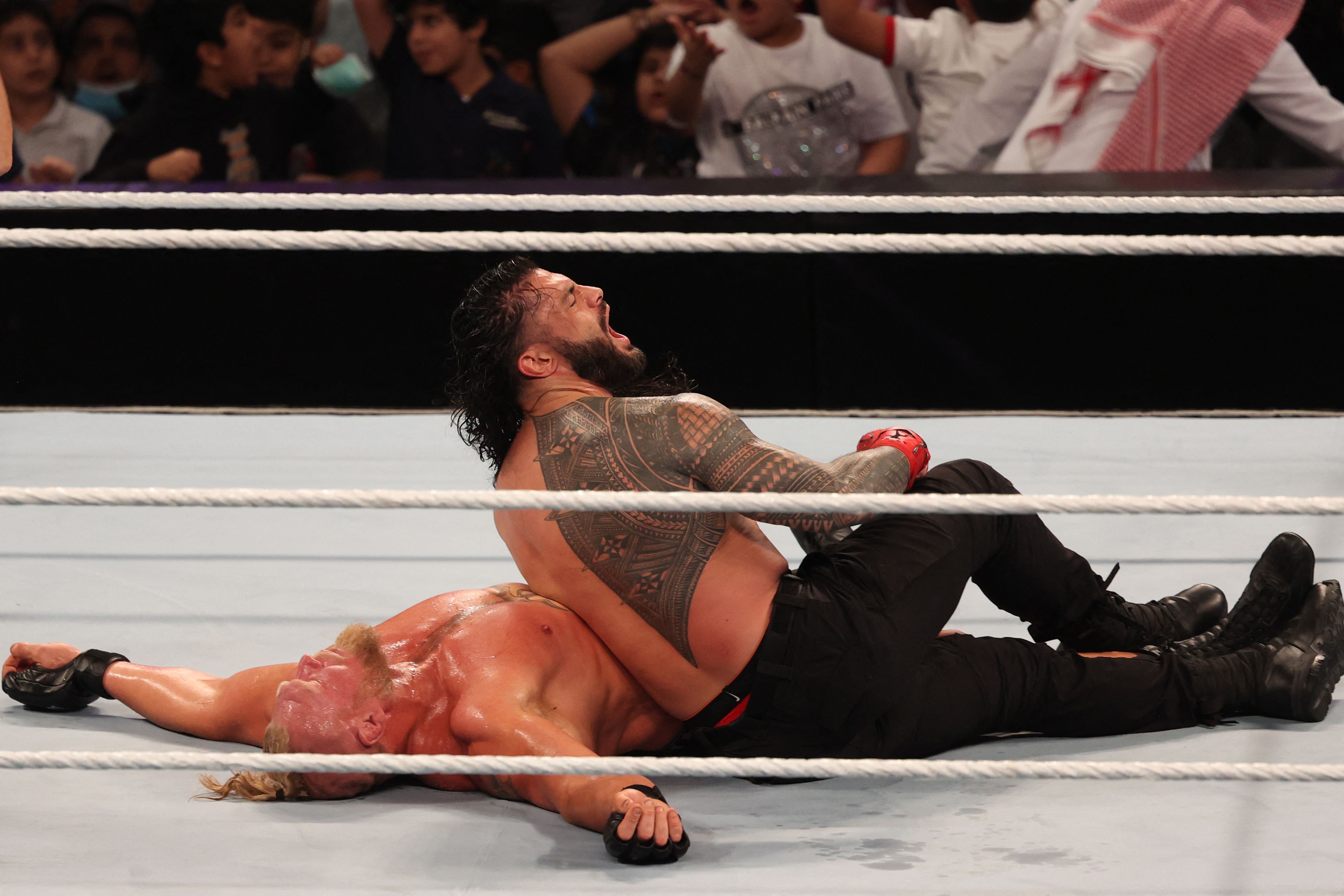 Roman Reigns (R) competes with Brock Lesnar during the World Wrestling Entertainment (WWE) Crown Jewel pay-per-view in the Saudi capital Riyadh on October 21, 2021. (Photo by Fayez Nureldine / AFP) (Photo by FAYEZ NURELDINE/AFP via Getty Images)