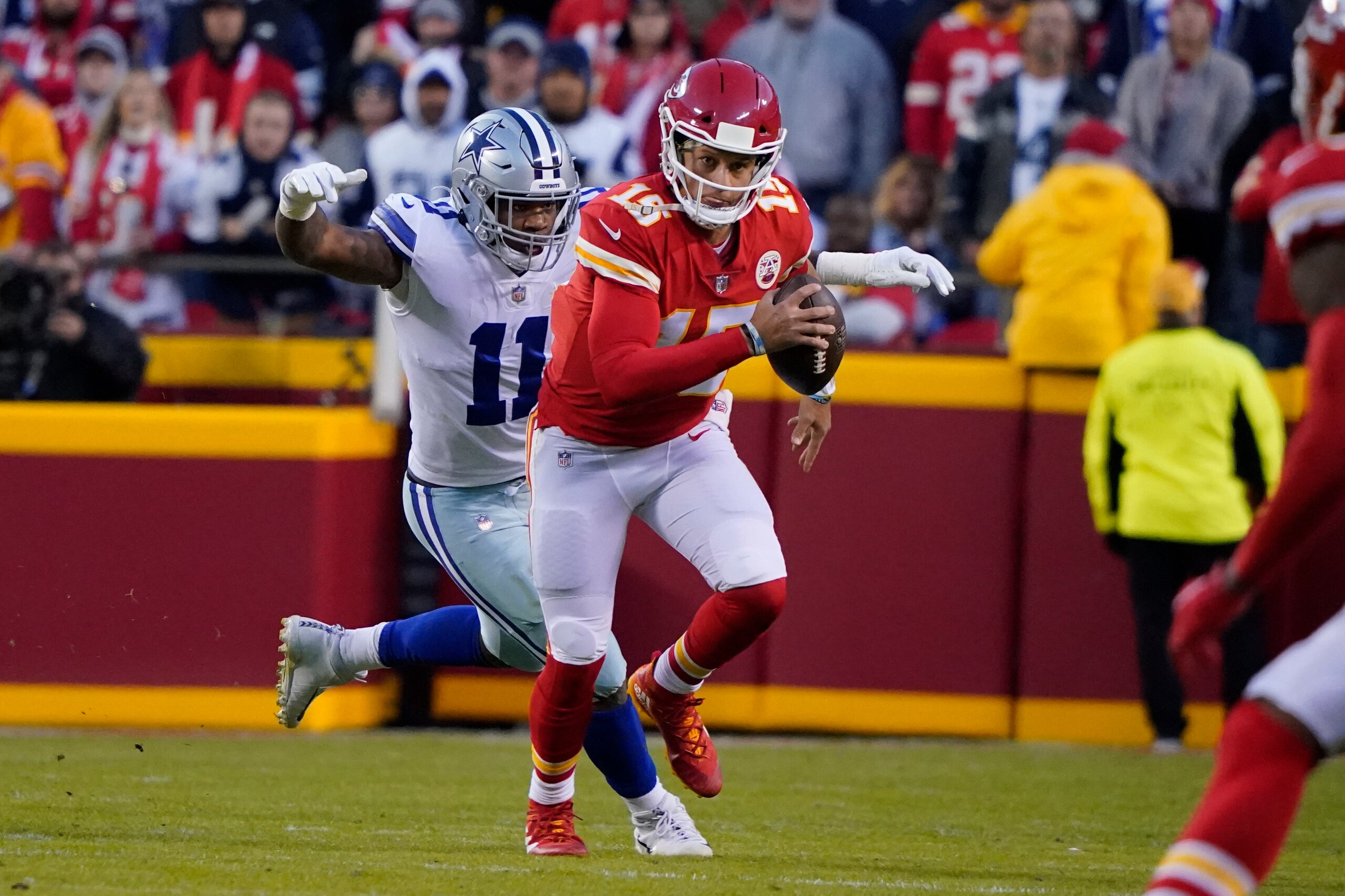 Kansas City Chiefs quarterback Patrick Mahomes (15) runs with the ball as Dallas Cowboys linebacker Micah Parsons (11) defends during the first half of an NFL football game Sunday, Nov. 21, 2021, in Kansas City, Mo. (AP Photo/Ed Zurga)