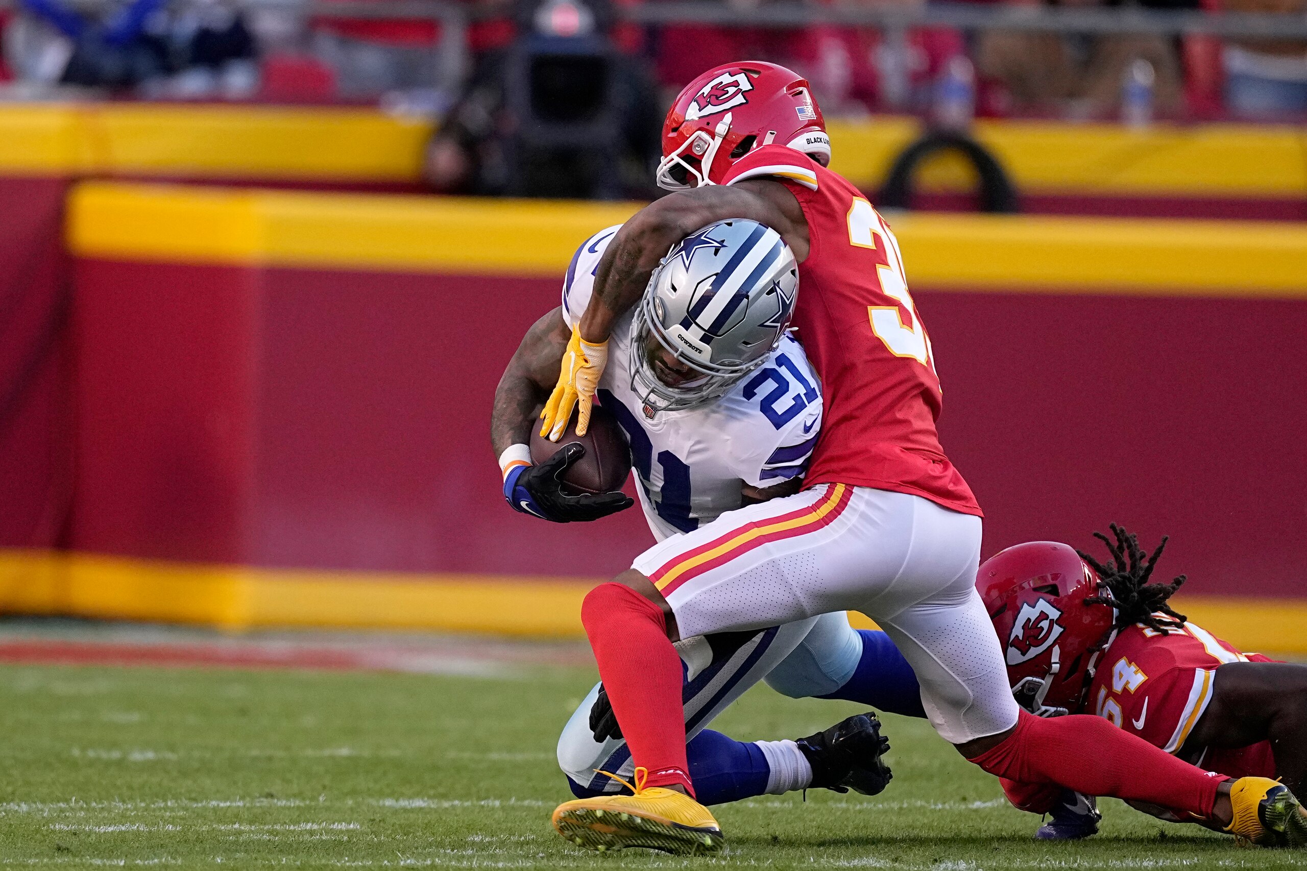Dallas Cowboys running back Ezekiel Elliott (21) is stopped by Kansas City Chiefs cornerback Charvarius Ward during the first half of an NFL football game Sunday, Nov. 21, 2021, in Kansas City, Mo. (AP Photo/Charlie Riedel)