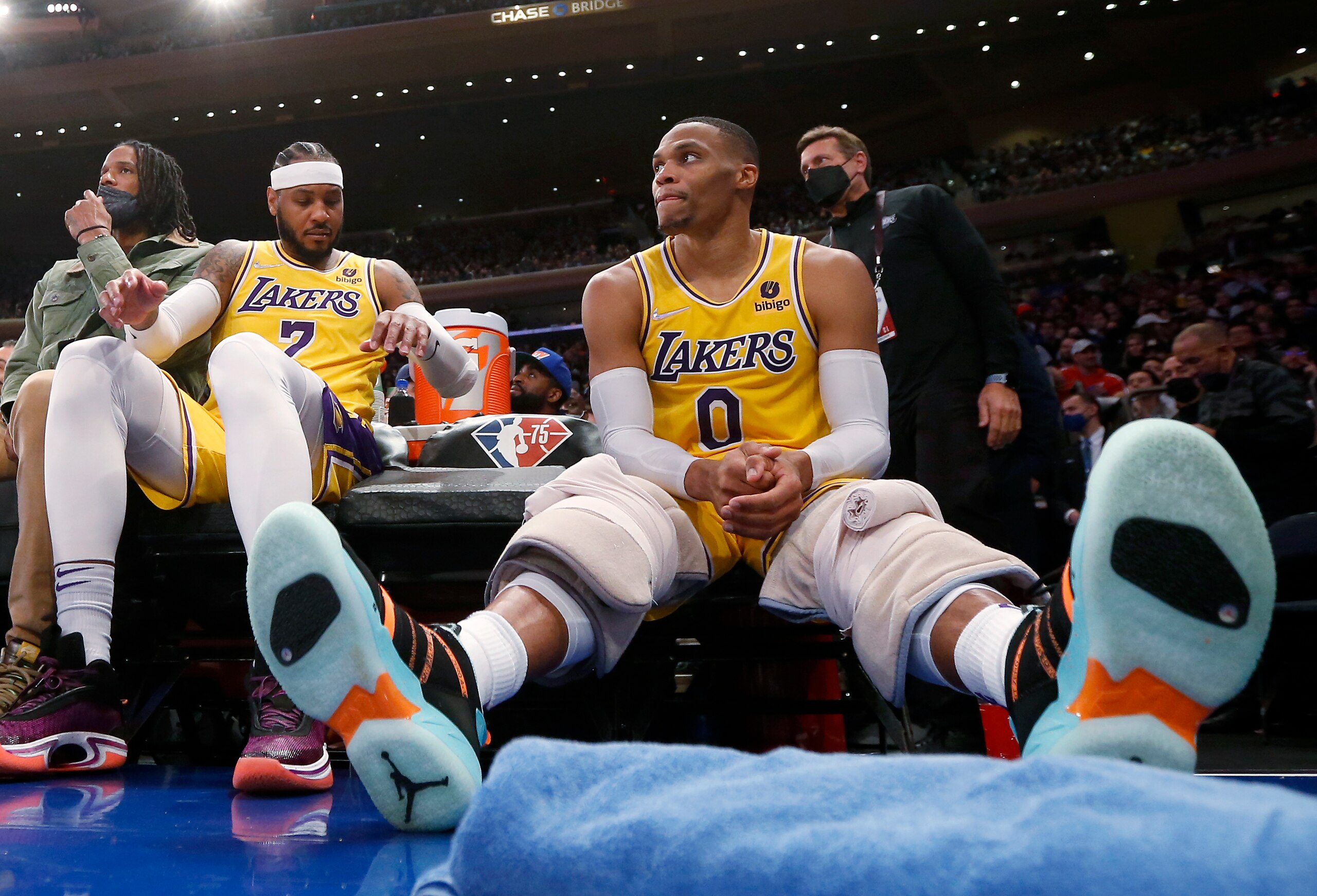 Los Angeles Lakers guard Russell Westbrook (0) sits on the bench next to forward Carmelo Anthony (7) during the second half of the team's NBA basketball game against the New York Knicks on Tuesday, Nov. 23, 2021, in New York. (AP Photo/Jim McIsaac)