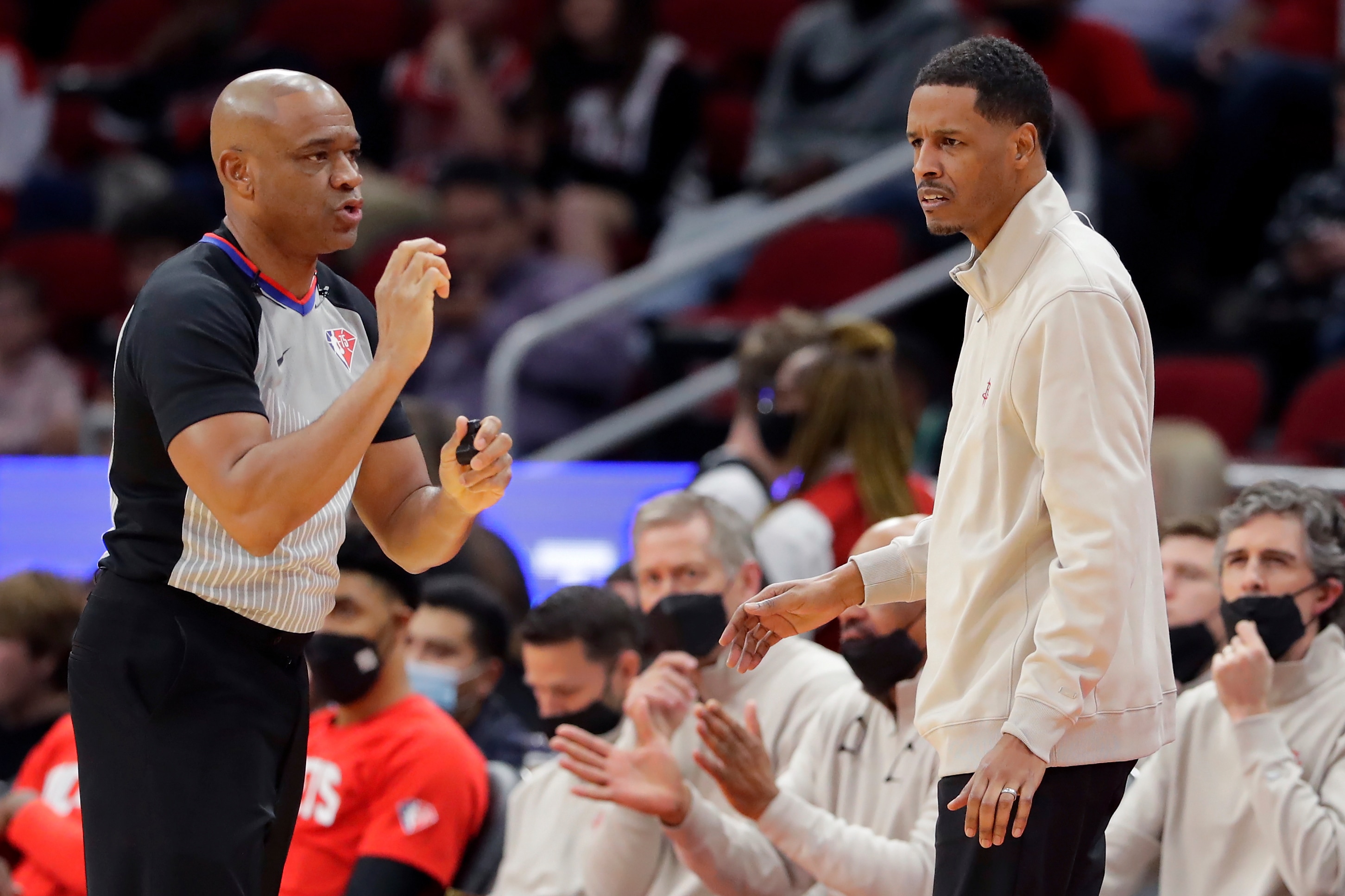 Referee Tre Maddox, left, calls a foul as Houston Rockets head coach Stephen Silas, right, looks on during the first half of an NBA basketball game Wednesday, Nov. 24, 2021, in Houston. (AP Photo/Michael Wyke)