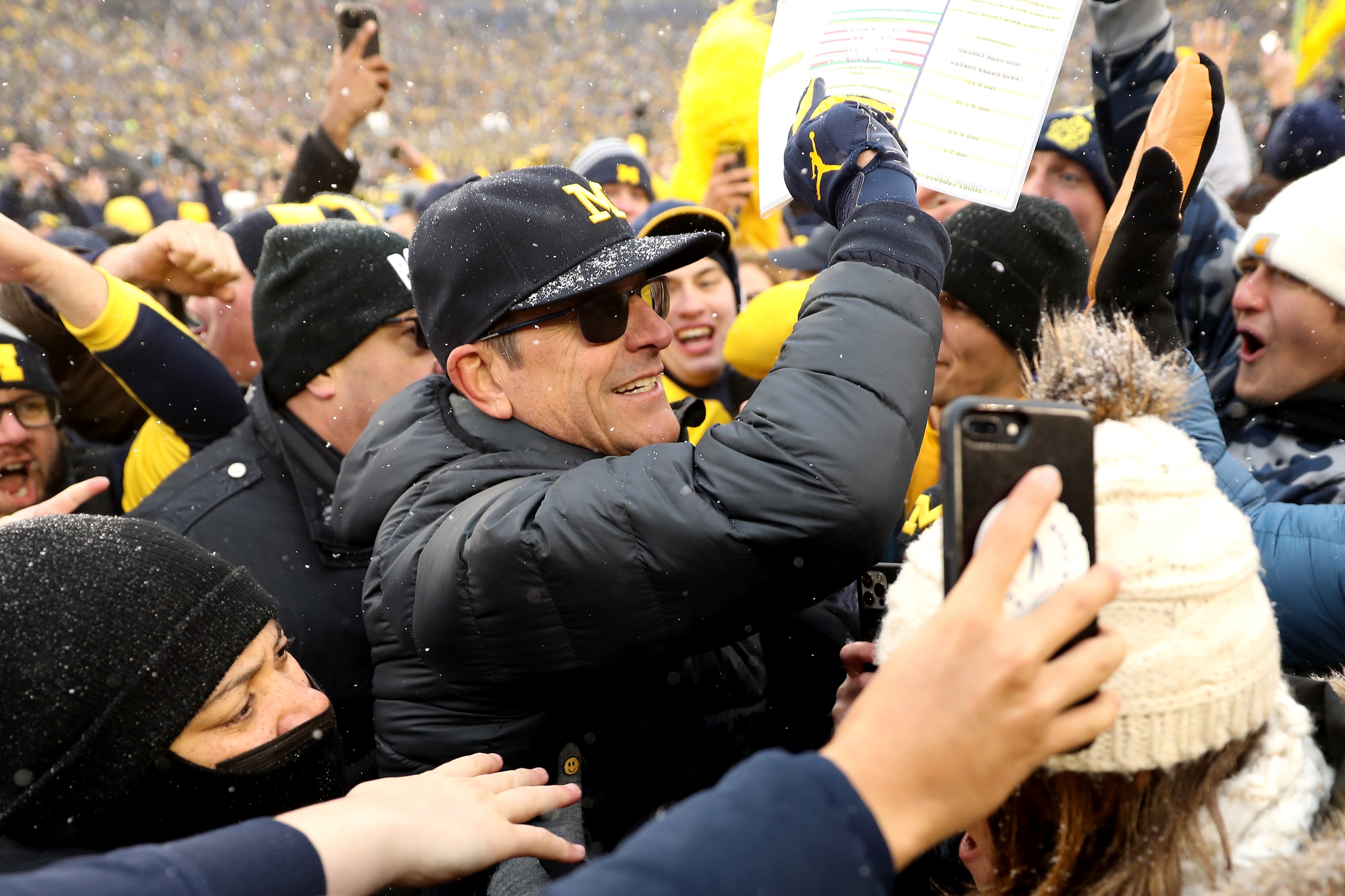 ANN ARBOR, MICHIGAN - NOVEMBER 27: Head Coach Jim Harbaugh of the Michigan Wolverines celebrates with fans after defeating the Ohio State Buckeyes at Michigan Stadium on November 27, 2021 in Ann Arbor, Michigan. (Photo by Mike Mulholland/Getty Images)