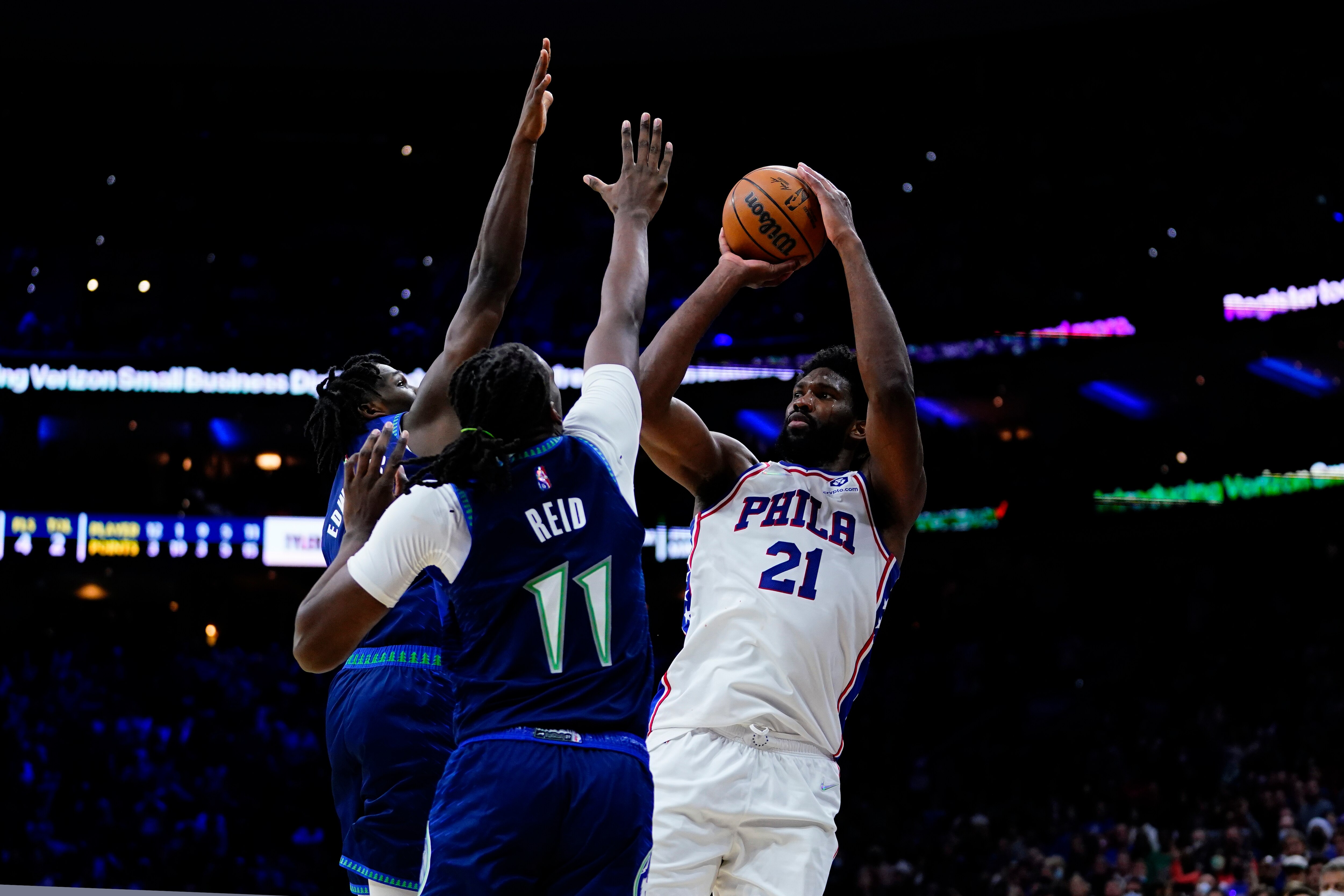 Philadelphia 76ers' Joel Embiid, right, cannot get a shot past Minnesota Timberwolves' Naz Reid, center, and Anthony Edwards during the final seconds of double overtime in an NBA basketball game, Saturday, Nov. 27, 2021, in Philadelphia. (AP Photo/Matt Slocum)