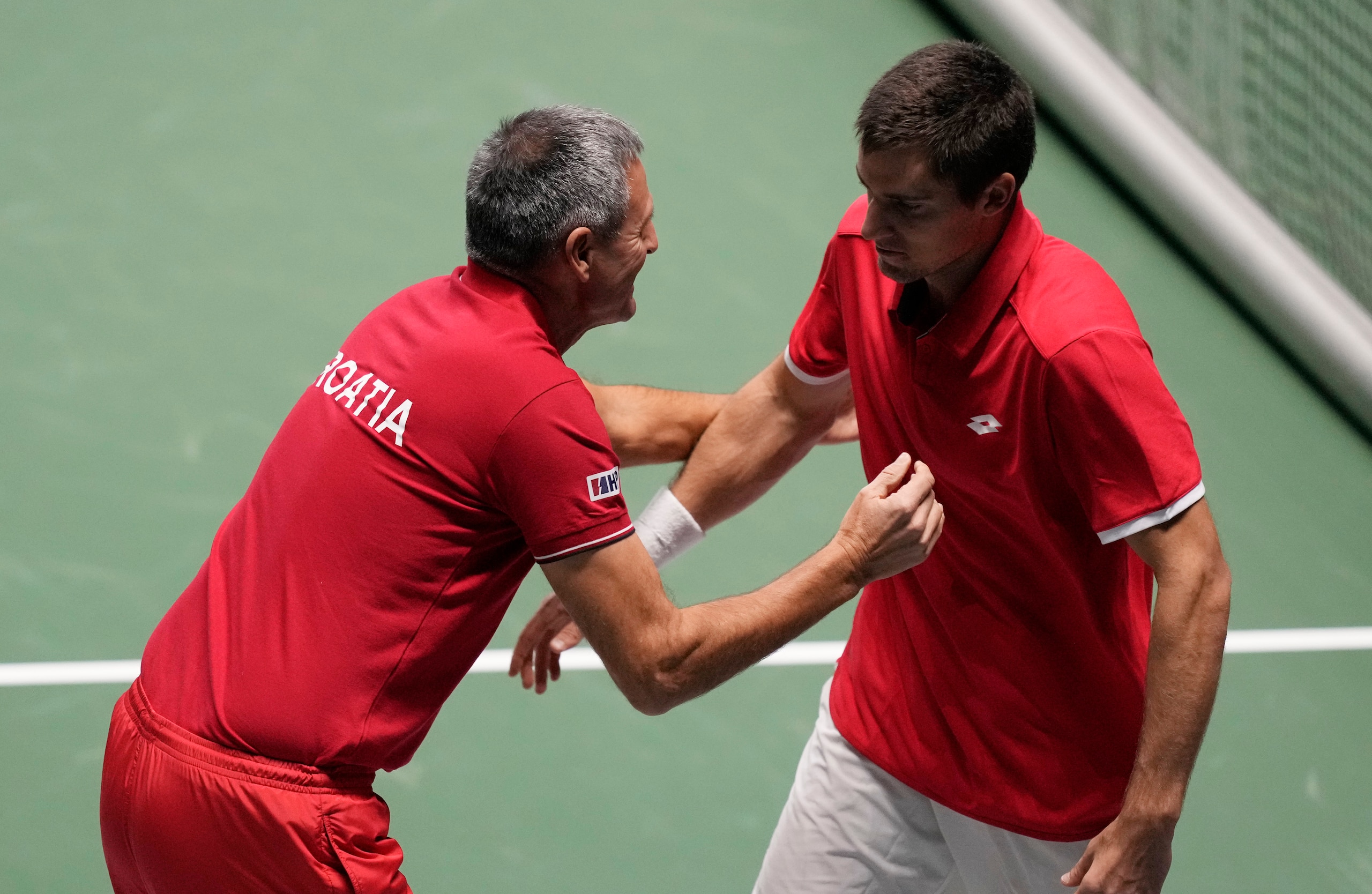 Croatia's Borna Gojo celebrates with his captain Vedran Martic after winning against Italy's Lorenzo Sonego during their Davis Cup men's single Finals tennis match at the Pala Alpitour in Turin, Italy, Monday, Nov. 29, 2021. (AP Photo/Antonio Calanni)