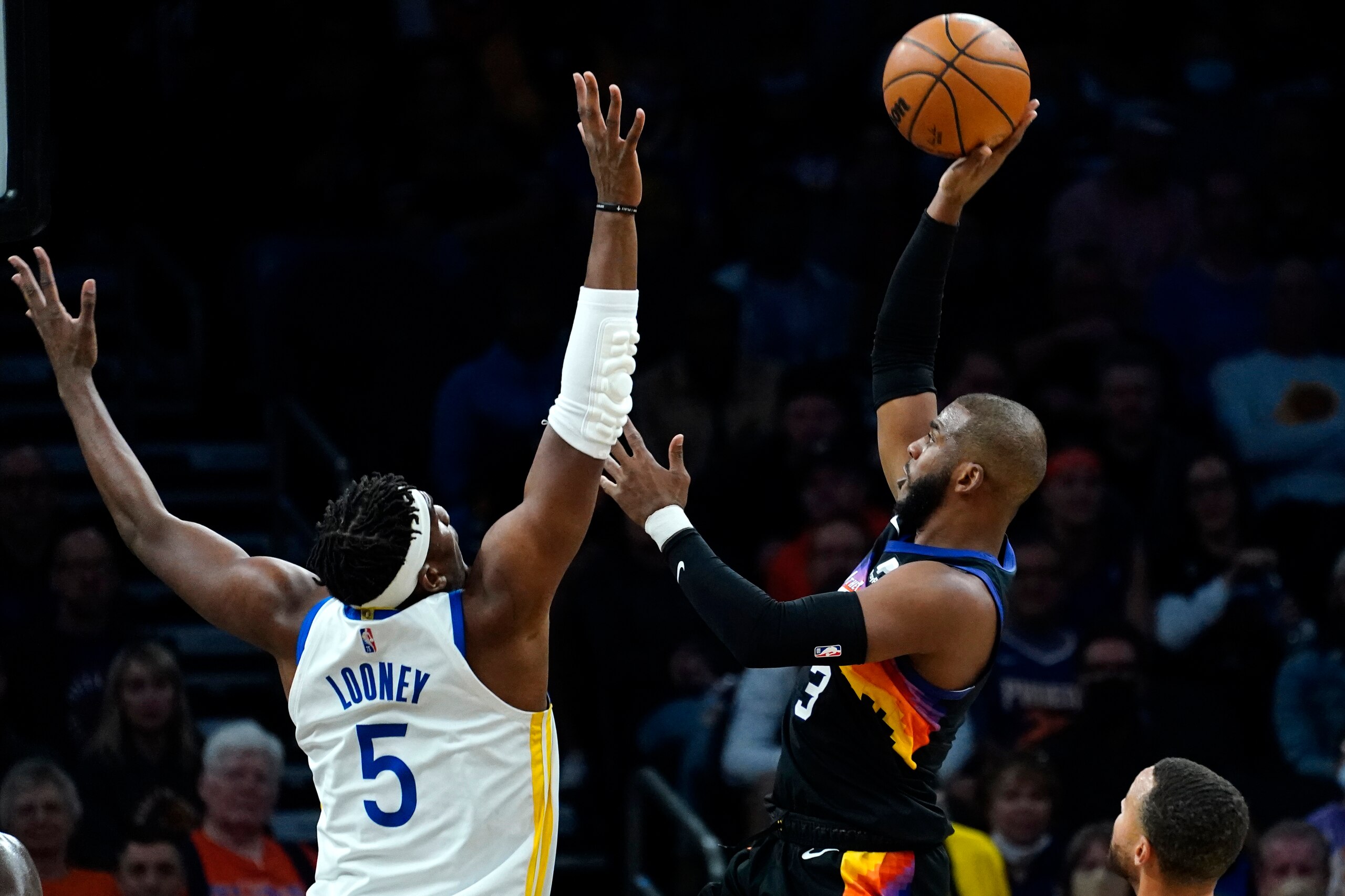 Phoenix Suns guard Chris Paul (3) shoots over Golden State Warriors center Kevon Looney (5) during the first half of an NBA basketball game, Tuesday, Nov. 30, 2021, in Phoenix. (AP Photo/Matt York)
