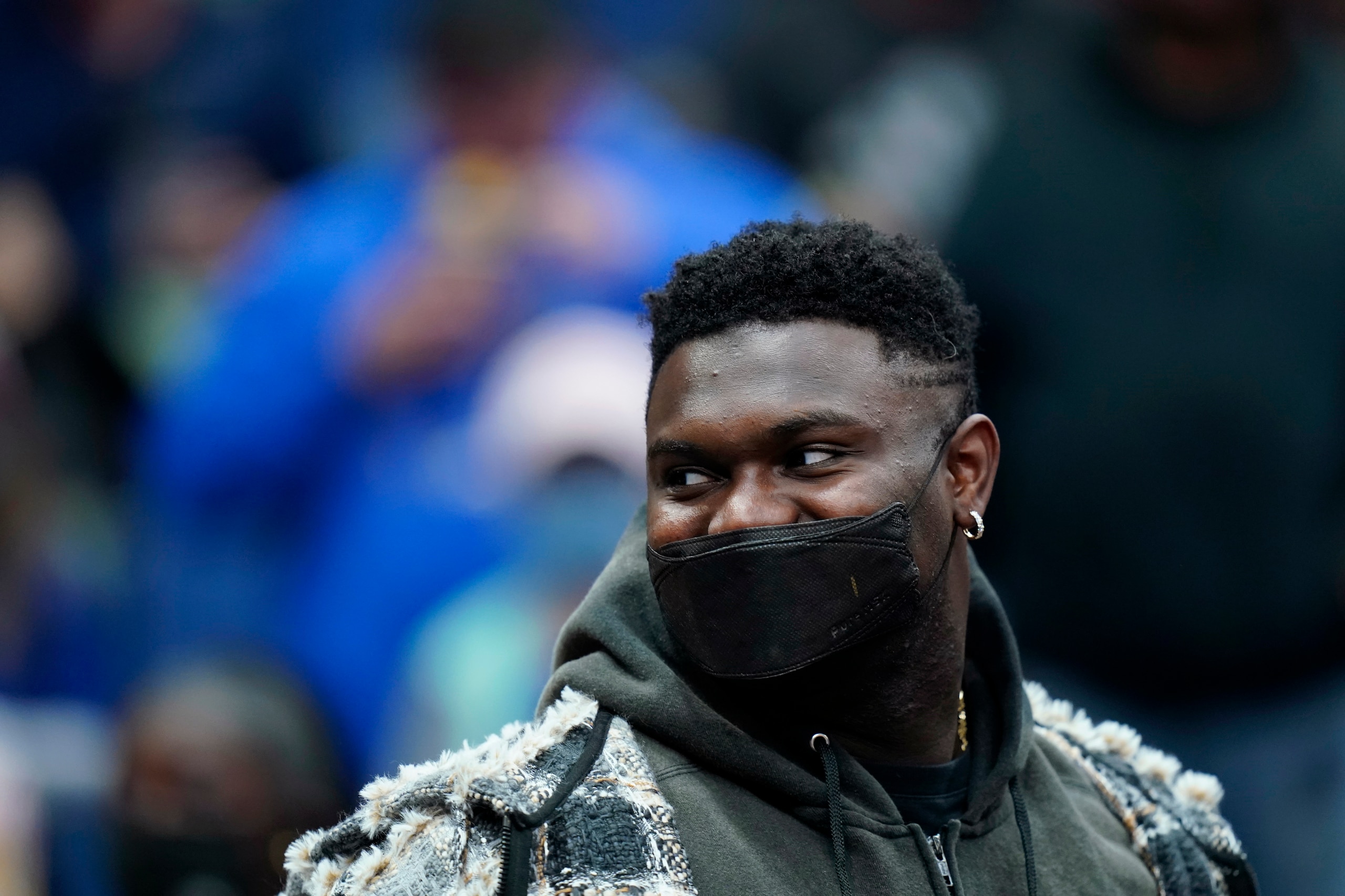 New Orleans Pelicans forward Zion Williamson sits on the bench in street clothes before the start of an NBA basketball game against the Memphis Grizzlies in New Orleans, Saturday, Nov. 13, 2021. (AP Photo/Gerald Herbert)