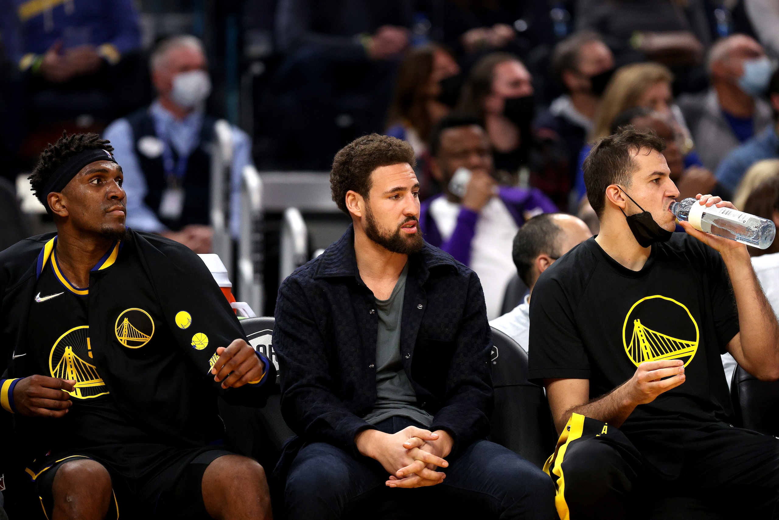 SAN FRANCISCO, CALIFORNIA - NOVEMBER 26: Kevon Looney #5, Klay Thompson #11 and Nemanja Bjelica #8 of the Golden State Warriors look on from the bench during the third quarter of the game against the Portland Trail Blazers at Chase Center on November 26, 2021 in San Francisco, California. NOTE TO USER: User expressly acknowledges and agrees that, by downloading and or using this photograph, User is consenting to the terms and conditions of the Getty Images License Agreement. (Photo by Ezra Shaw/Getty Images)