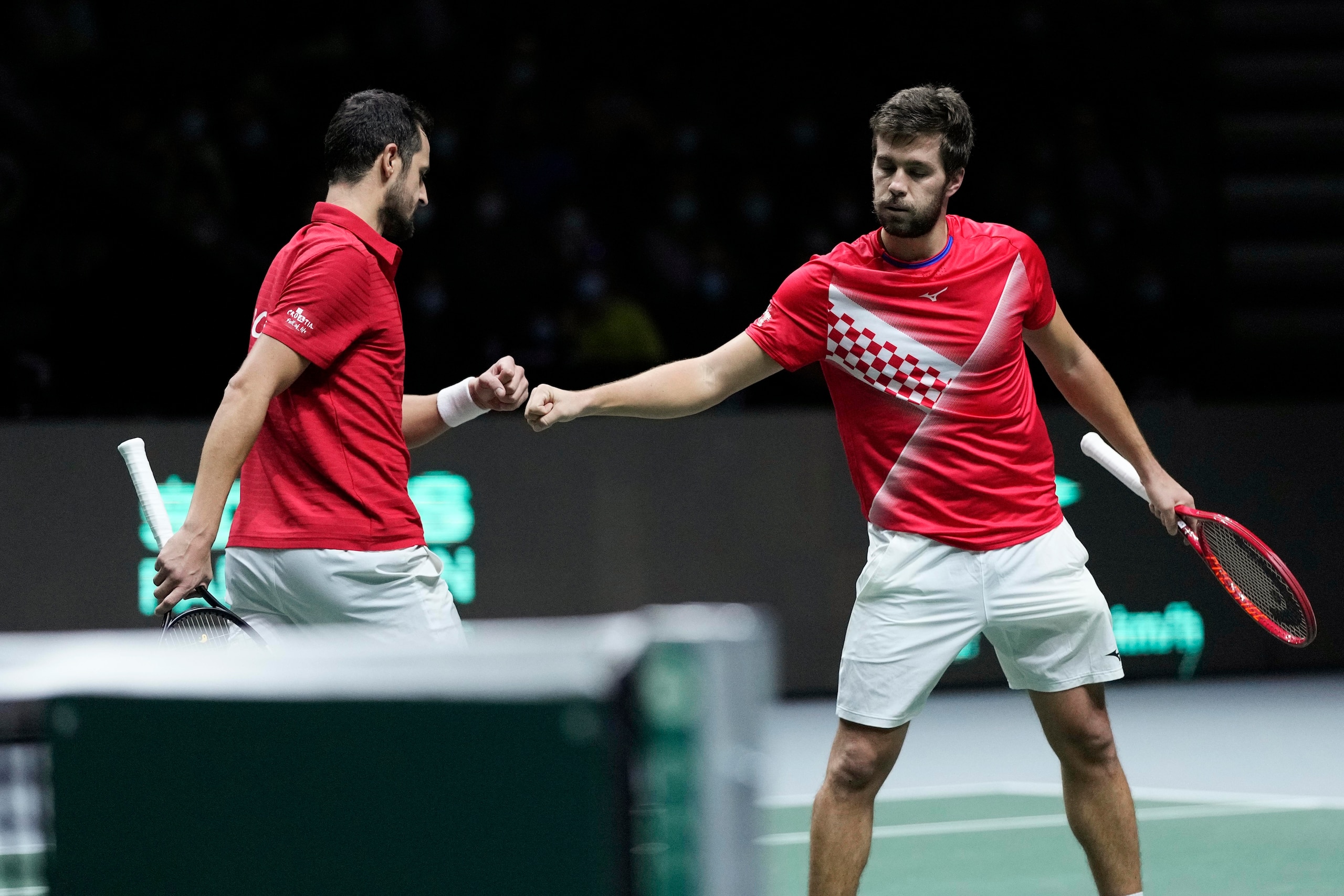 Croatia's Mate Pavic, left, celebrates with his teammate Nikola Mektic after defeating Serbia's Novak Djokovic during their Davis Cup tennis semi-final match at Madrid Arena in Madrid, Spain, Friday, Dec. 3, 2021. (AP Photo/Bernat Armangue)