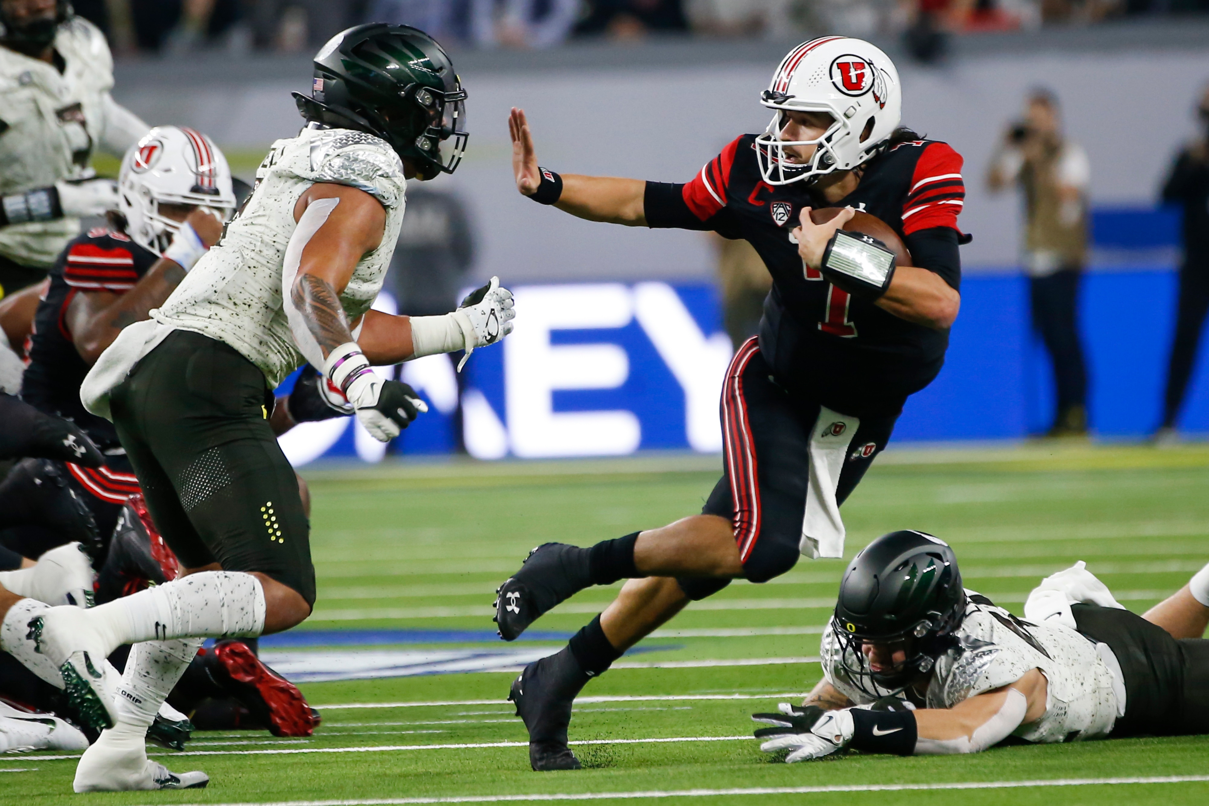 Utah quarterback Cameron Rising, right, runs the ball under pressure from Oregon linebacker Noah Sewell during the first half of the Pac-12 Conference championship NCAA college football game Friday, Dec. 3, 2021, in Las Vegas. (AP Photo/Chase Stevens)