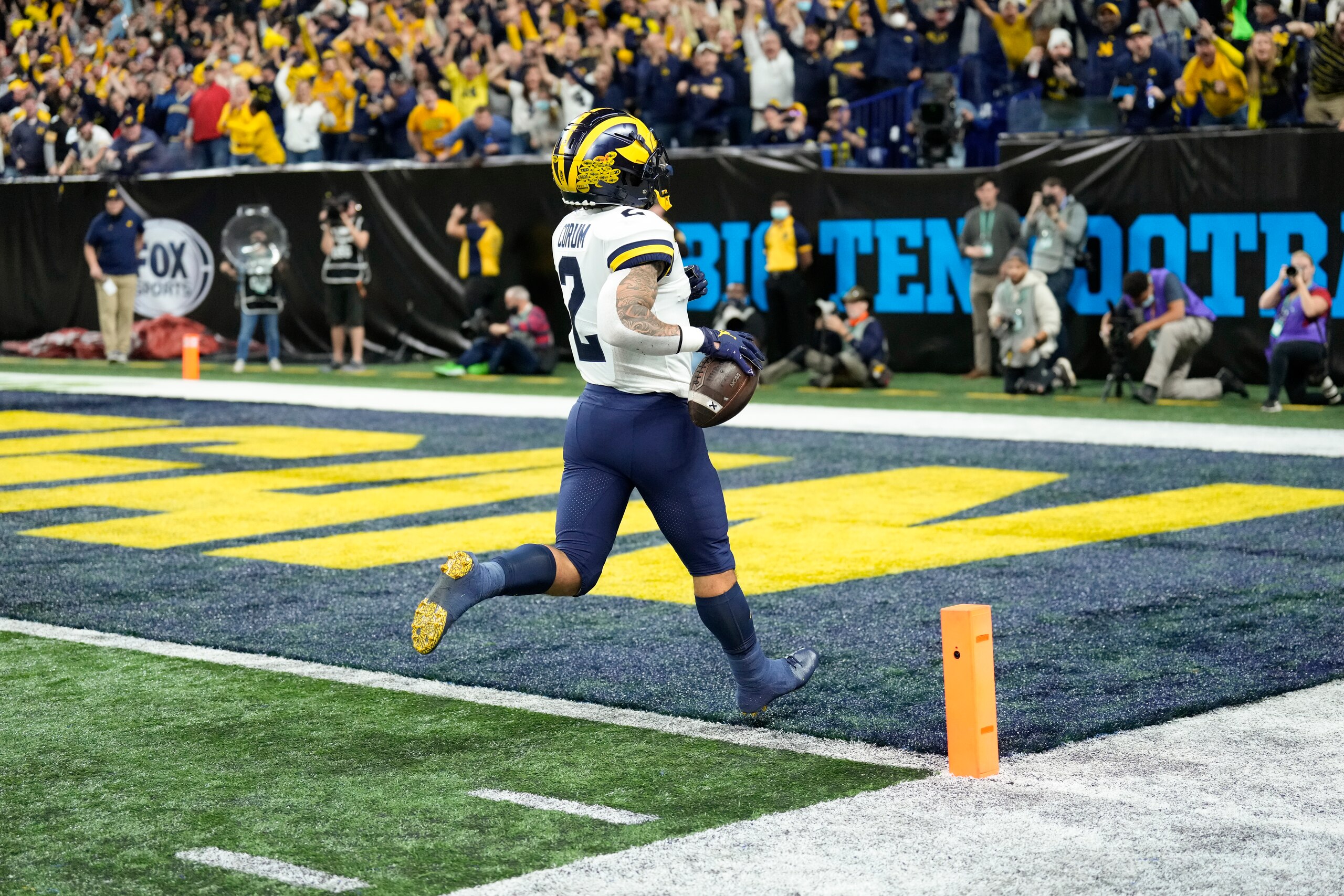 Michigan running back Blake Corum (2) scores on a 67-yard touchdown run during the first half of the Big Ten championship NCAA college football game against Iowa, Saturday, Dec. 4, 2021, in Indianapolis. (AP Photo/AJ Mast)