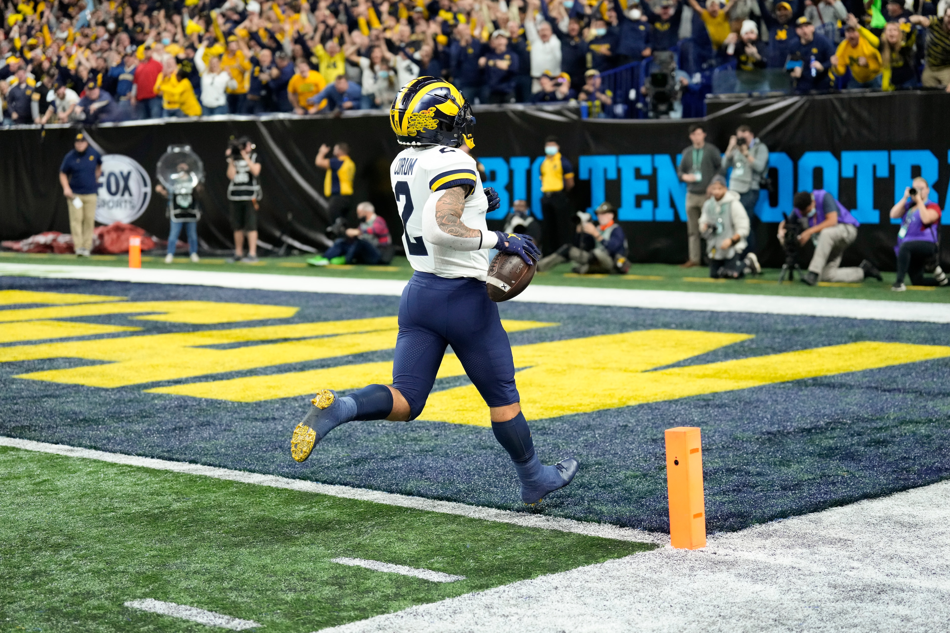 Michigan running back Blake Corum (2) scores on a 67-yard touchdown run during the first half of the Big Ten championship NCAA college football game against Iowa, Saturday, Dec. 4, 2021, in Indianapolis. (AP Photo/AJ Mast)