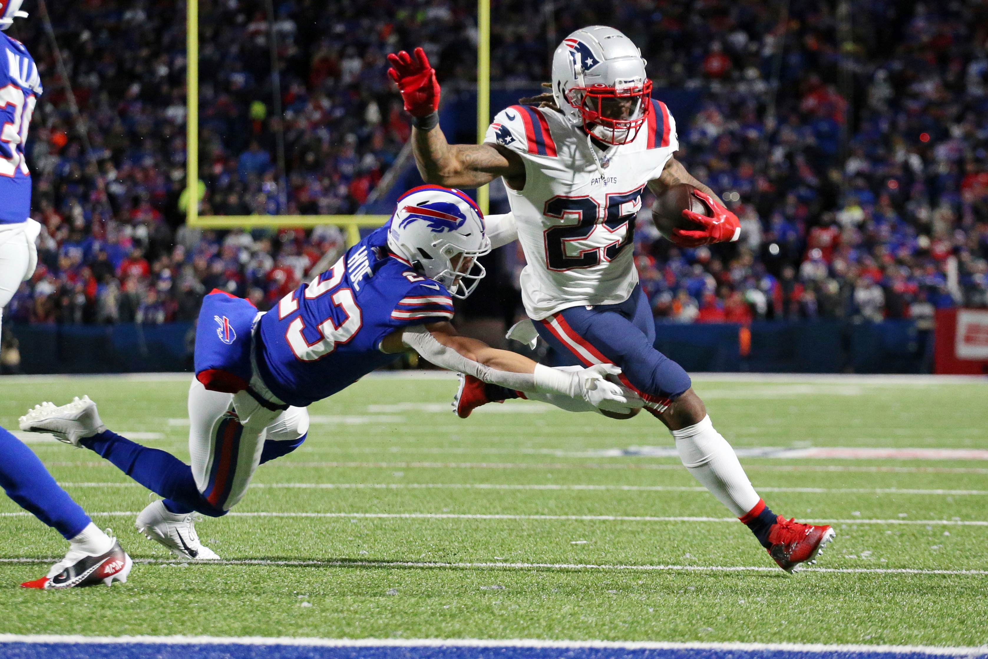 New England Patriots running back Brandon Bolden (25) gets past Buffalo Bills safety Micah Hyde (23) for a two-point conversion after a touchdown run by Patriots running back Damien Harris during the first half of an NFL football game in Orchard Park, N.Y., Monday, Dec. 6, 2021. (AP Photo/Joshua Bessex )