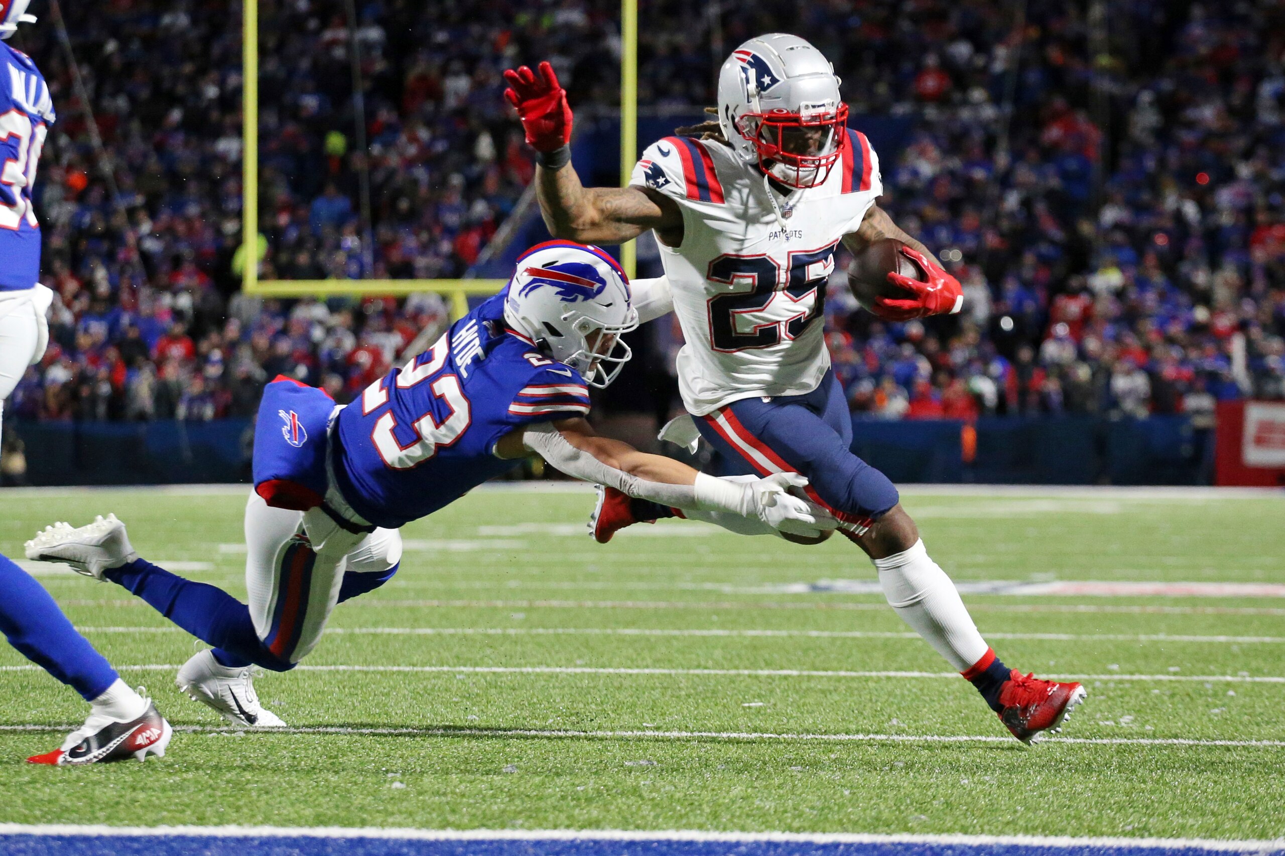New England Patriots running back Brandon Bolden (25) gets past Buffalo Bills safety Micah Hyde (23) for a two-point conversion after a touchdown run by Patriots running back Damien Harris during the first half of an NFL football game in Orchard Park, N.Y., Monday, Dec. 6, 2021. (AP Photo/Joshua Bessex )